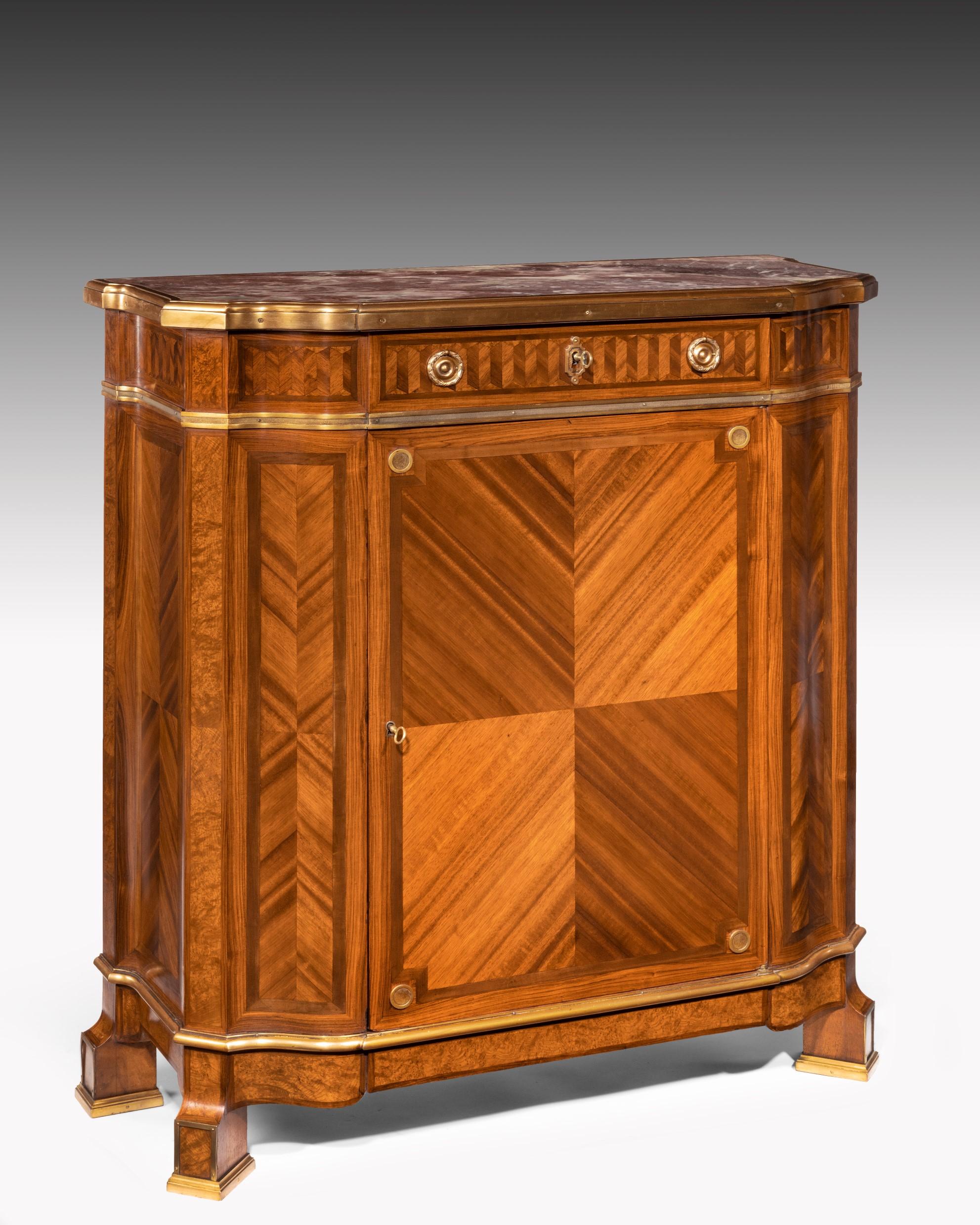 A fine quality gilt bronze-mounted Kingwood and burr maple marble topped side cabinet by Maison Soubrier, Pairs, circa 1900.

The shaped D-fronted Rouge Royal marble top within a looped molded gilt strapwork above a Kingwood chevron banded frieze,