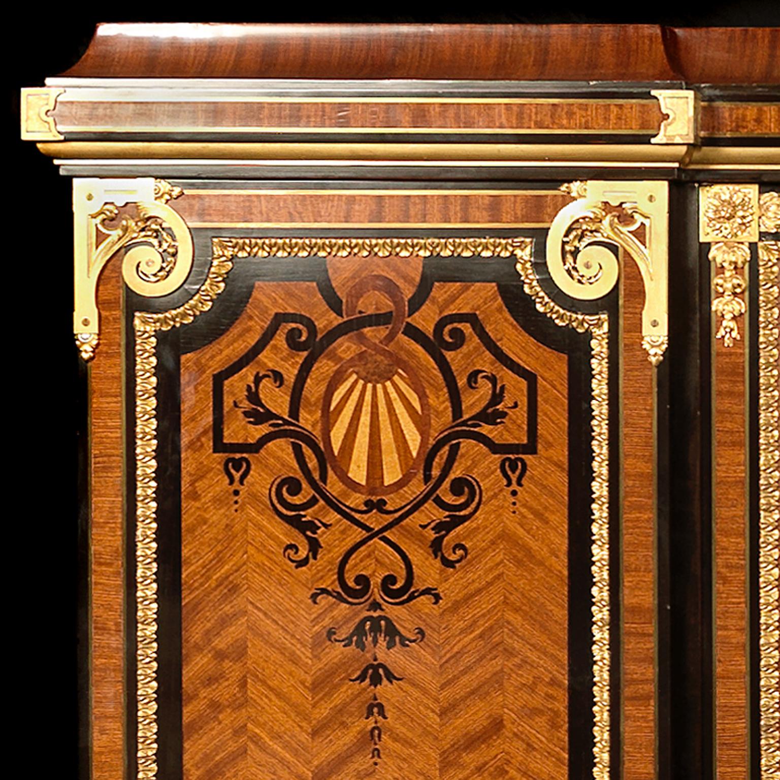 A Very Large and Impressive Gilt-Bronze Mounted and Marquetry Inlaid Bookcase.

Signed to the lock on the central door ‘Les Fils Chambon’.   

This very fine marquetry bookcase has a moulded cornice above a narrow central glazed door flanked to each
