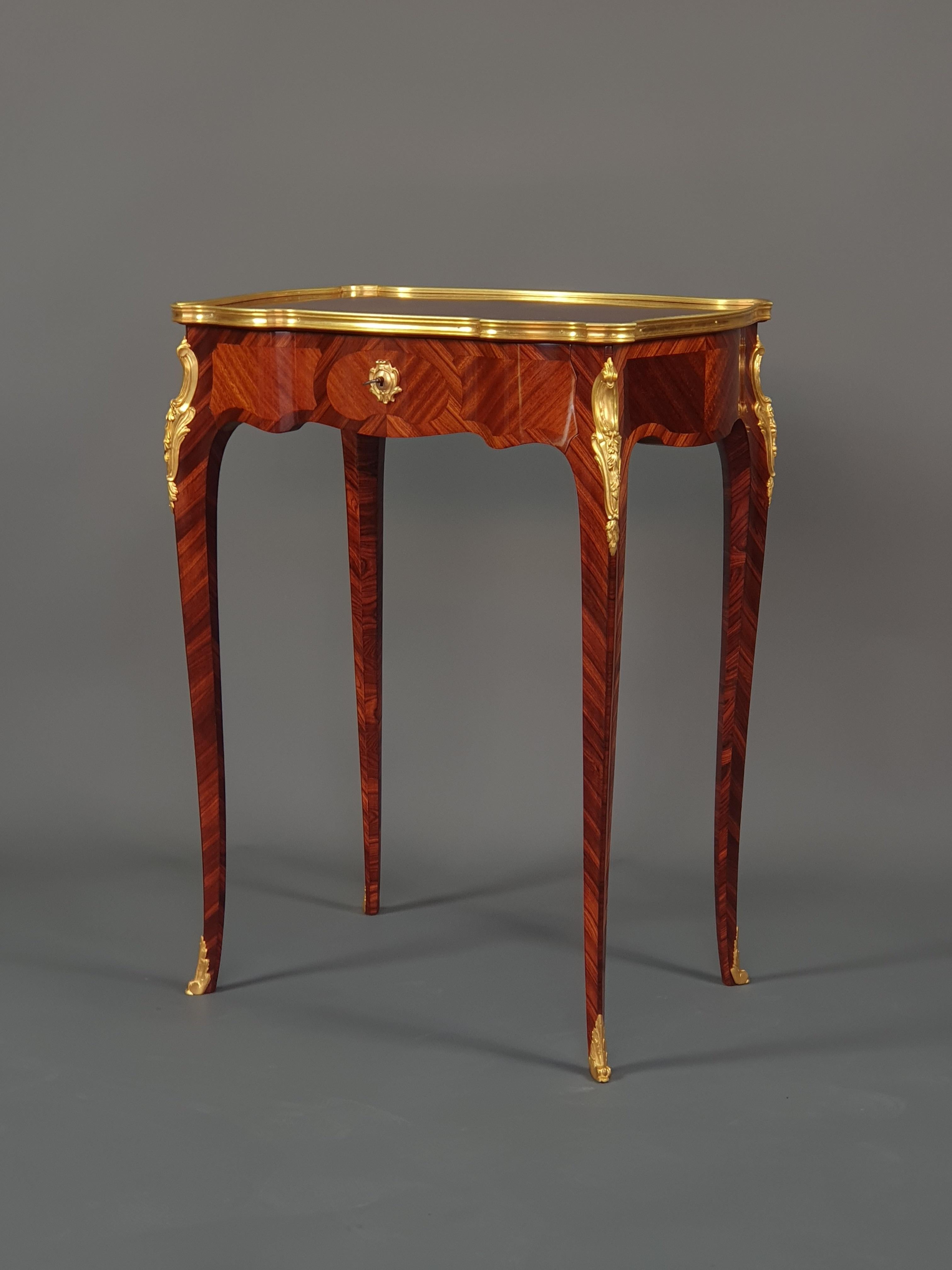 Sehr elegante Louis XV-Stil table d'appoint in Palisander und Mahagoni Intarsien in Reserven, sehr fein ziseliert vergoldeter Bronze Ornamentik. Vier leicht geschwungene Beine präsentieren eine Platte mit gewundenen und asymmetrischen
