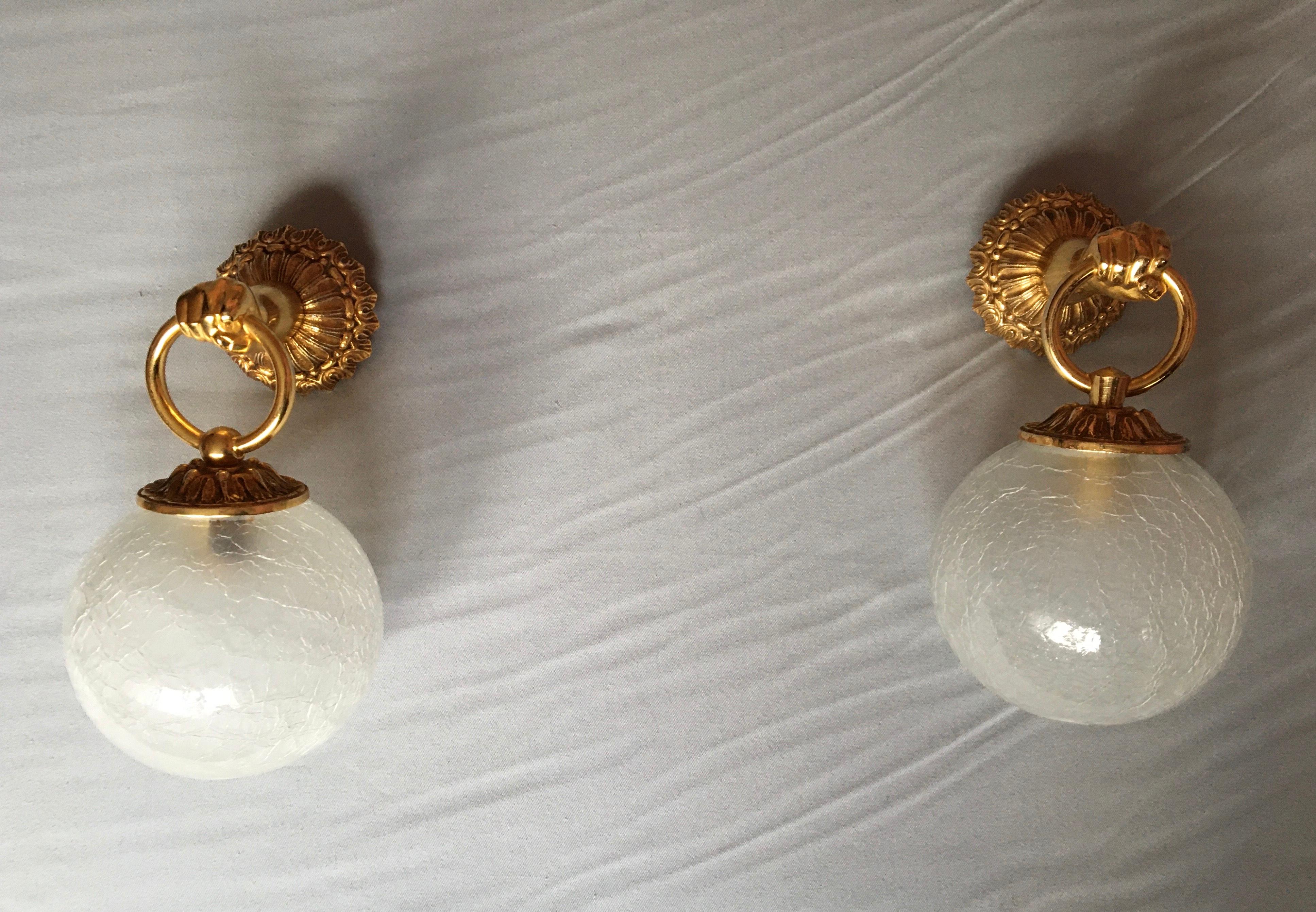 Beautiful pair of French mid 60’s wall sconces in gilted metal with crackled thick glass globe.

The pair is in very good condition and electricity fit the Us Standard (baionnet bulb holder, 60 watts maxi per shade).

The ring attachment part of