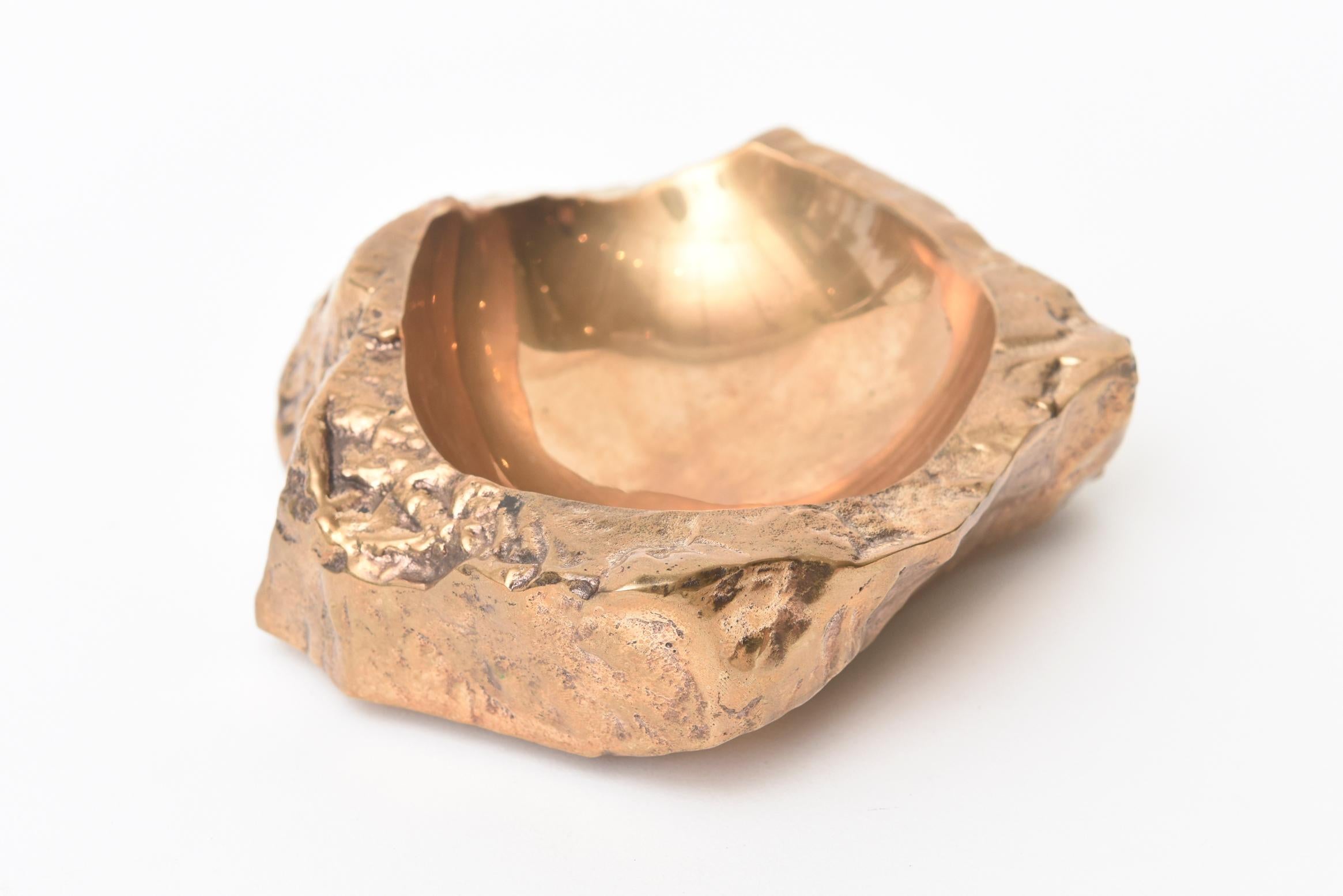This chunky and heavy French gilt bronze vida poche bowl is like an organic nugget. It makes a great desk accessory or console or cocktail table addition. It is sculpture in the way of a bowl that has been gilded over the bronze. It is from the