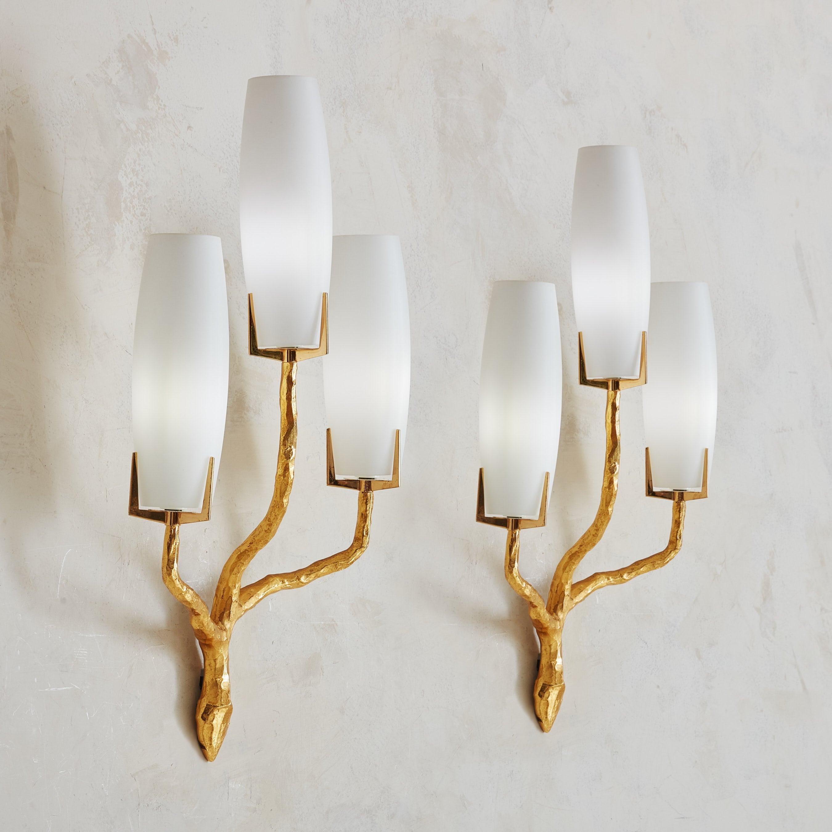 A gorgeous French sconce designed by Felix Agostini for Maison Arlus in the 1960s. Crafted from cast gilt bronze, this sconce features a striking three-arm silhouette meticulously designed in the form of stylized branches. The organic shape of the