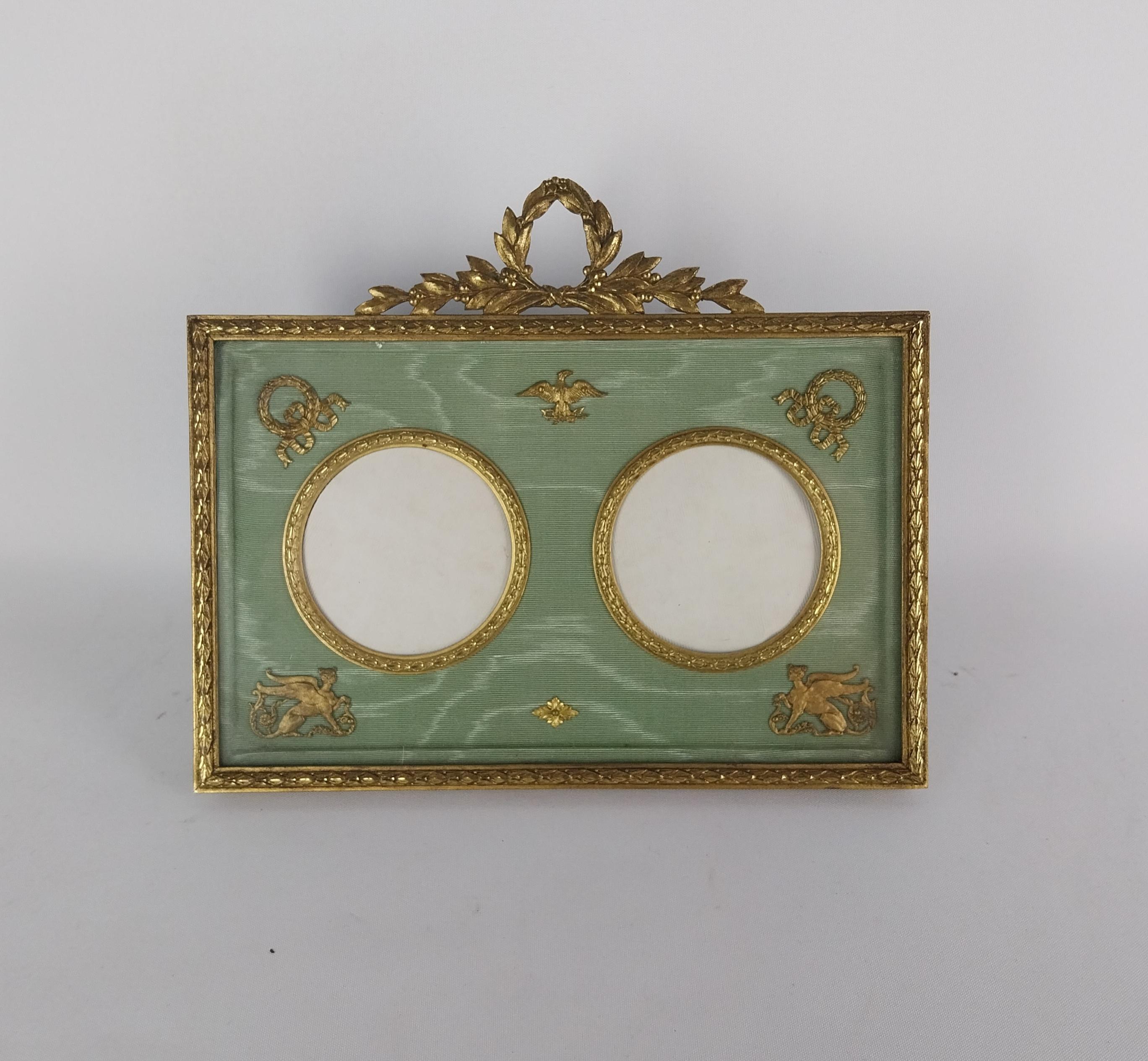Marco de fotos de bronce dorado de estilo Imperio francés con dos aberturas para fotos de 58 mm de ancho, tela de seda original con marcas de agua, cada esquina del marco tiene monturas doradas con una esfinge francesa en las esquinas inferiores y 
