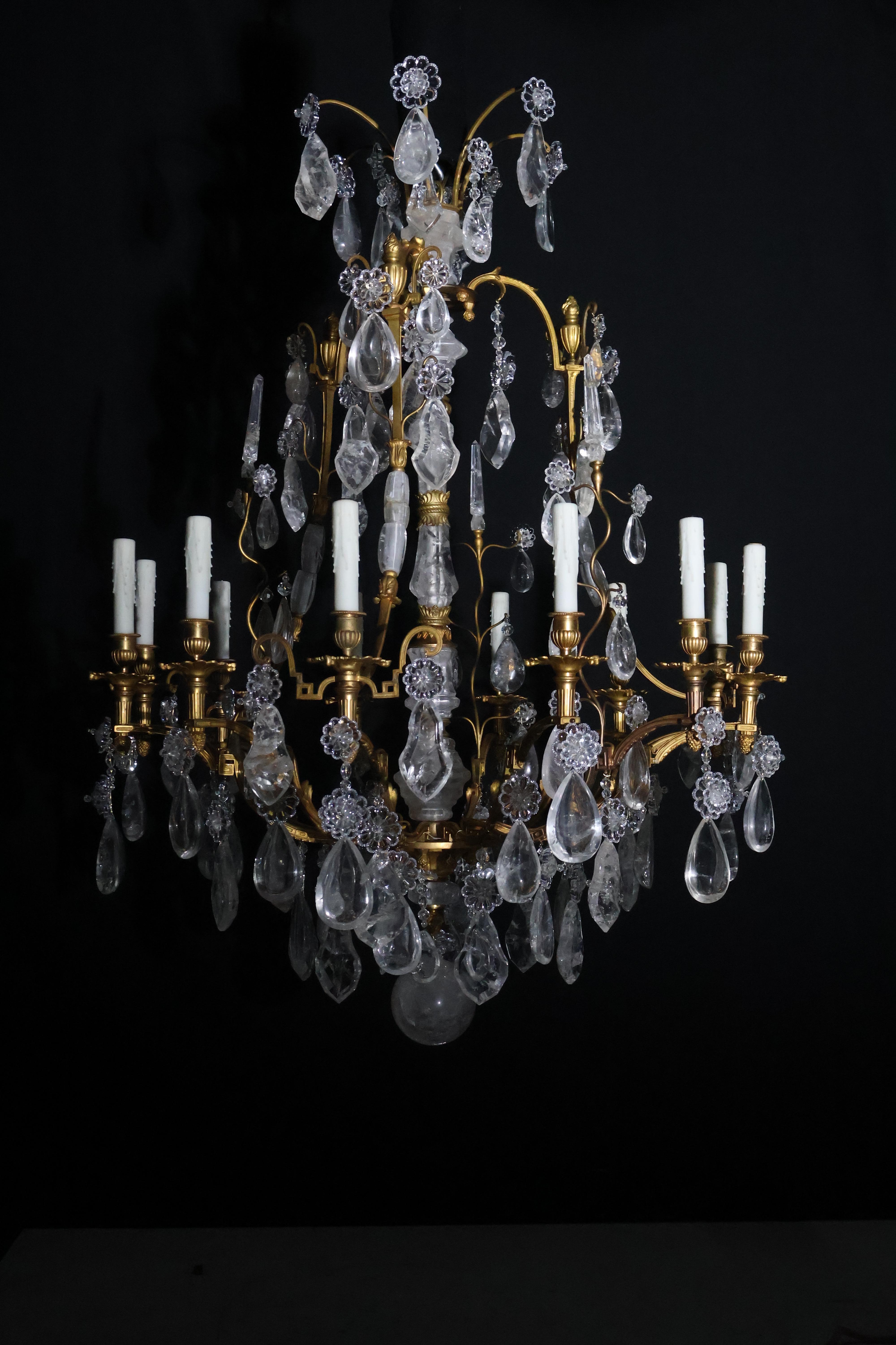 Showstopper gilt bronze and rock crystal chandelier, originally for candles (now electrified) featuring central rod with multiple rock crystal faceted segments intersected by gilt bronze supports. The overall pear shaped frame with square section