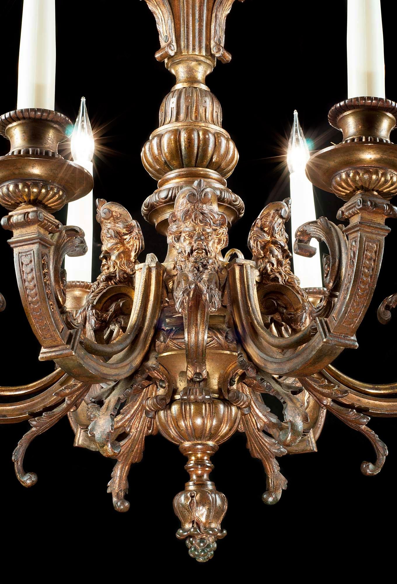 A large and impressive gilt bronze six branch Baroque style chandelier the central baluster stem is topped by a corona above three small caryatid figures and beneathe them interseprsed between the branches are five grotesque masks, the stem