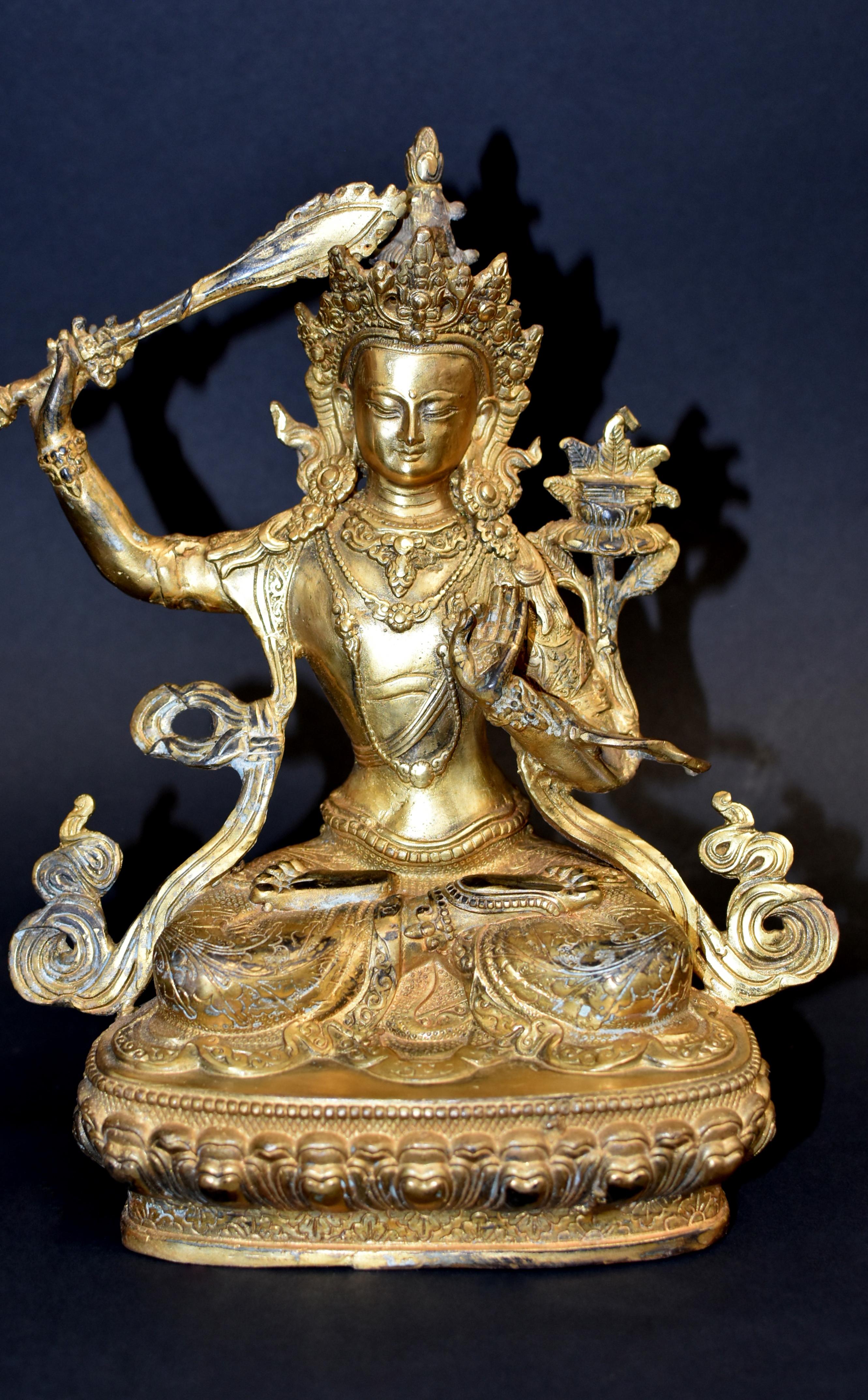 A beautiful gilt bronze, 3.4 lb, statue of Tibetan Bodhisattva Manjushree. Legend has it that he cuts water with the sword to divide the water resource to irrigate dry valleys. In Tibetan Buddhism, Mañjusri also manifests in a wrathful tantric form