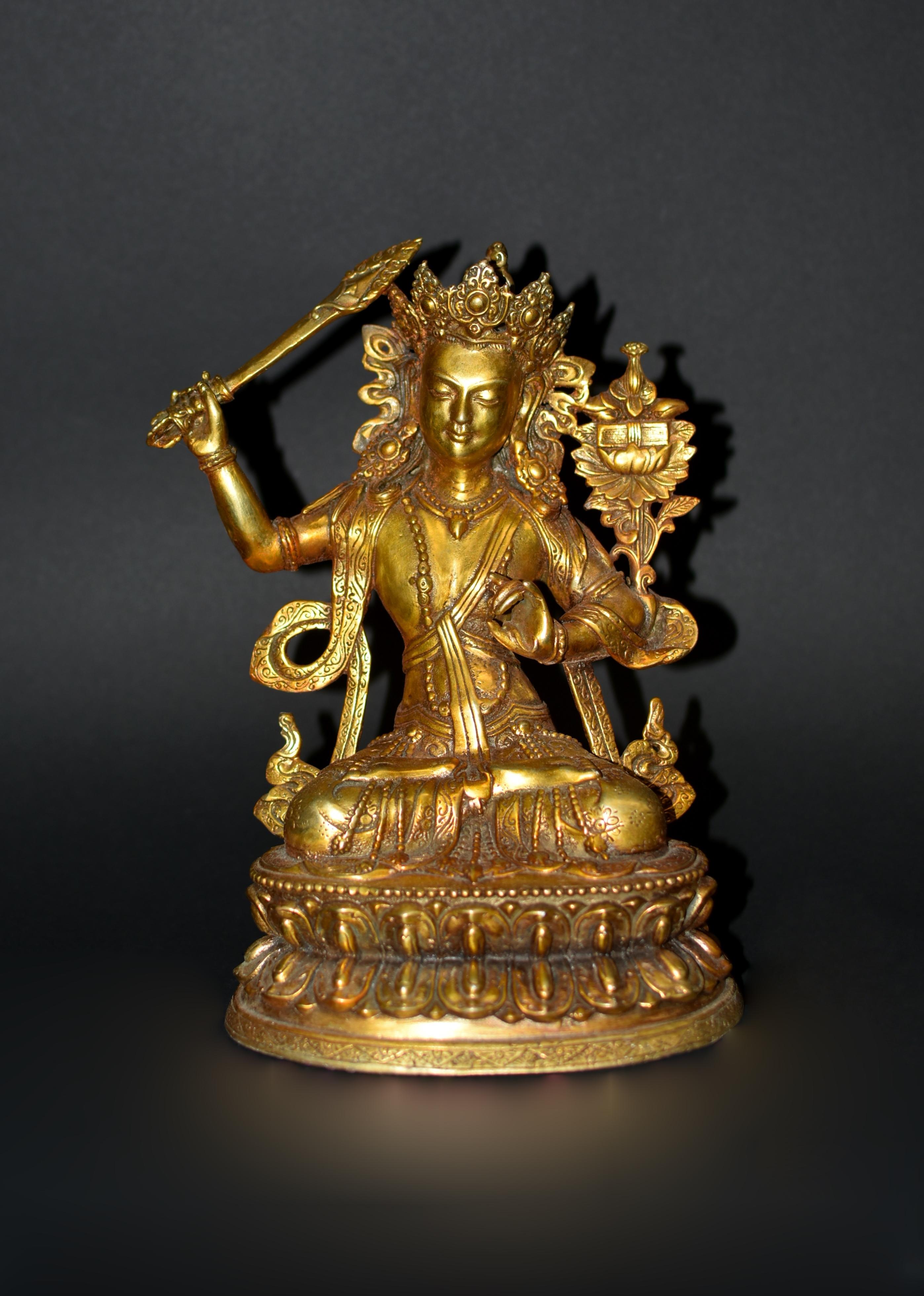 A beautiful gilt bronze, 4.6 lb, statue of Tibetan Bodhisattva Manjushree. Seated in vajrasana on a double lotus throne, in his right hand the sword of wisdom and his left hand in jnana mudra, gesture of teaching. Adorned with jewels and dressed in
