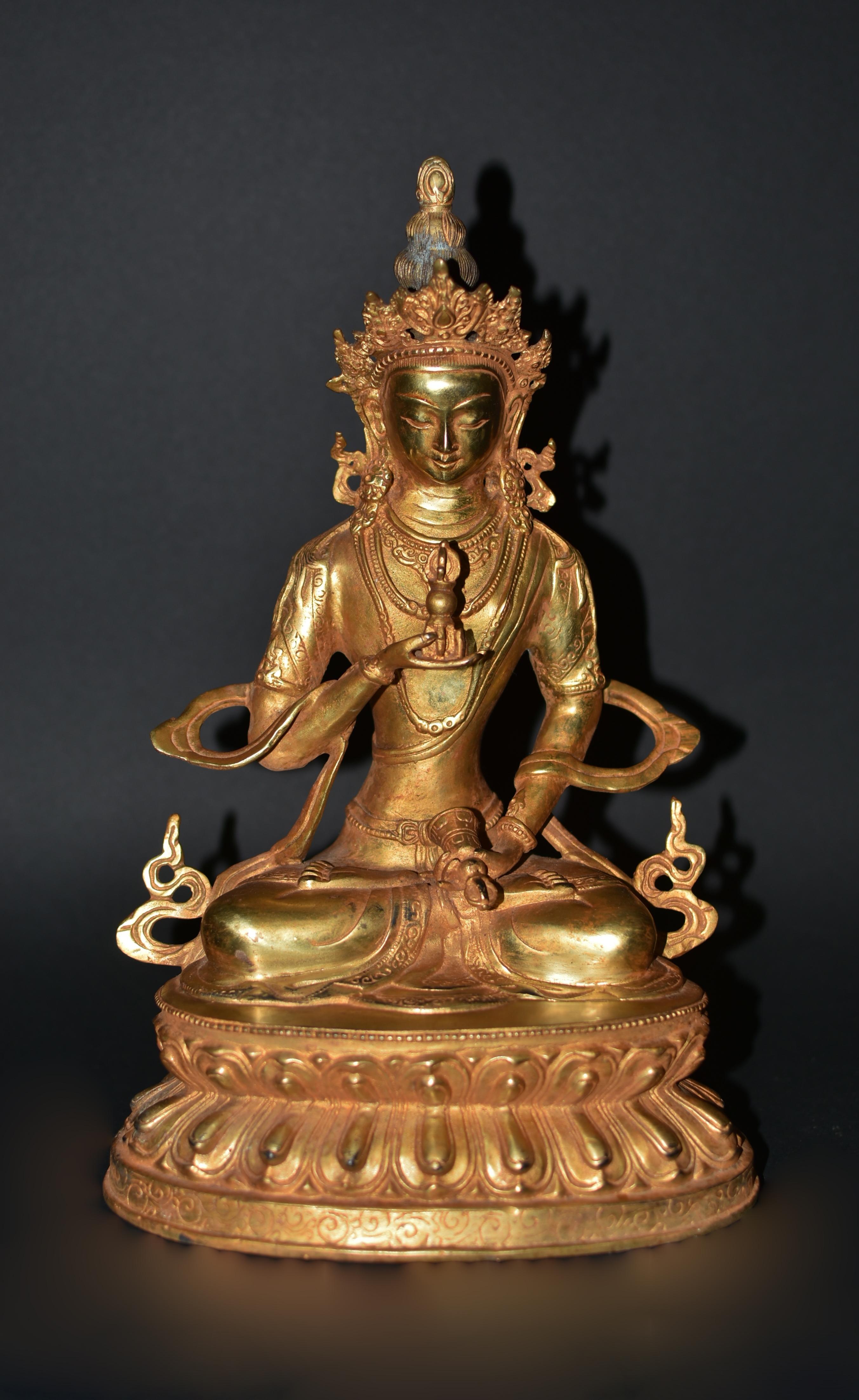 A beautiful, 7 lb, gilt bronze Tibetan sculpture of Buddha Vajrasatwa. Seated dhyana asana on double lotus throne, left hand holding a ghanta bell, right hand holding vajra thunderbolt, scepters of combined male and female energy to conquer evil.