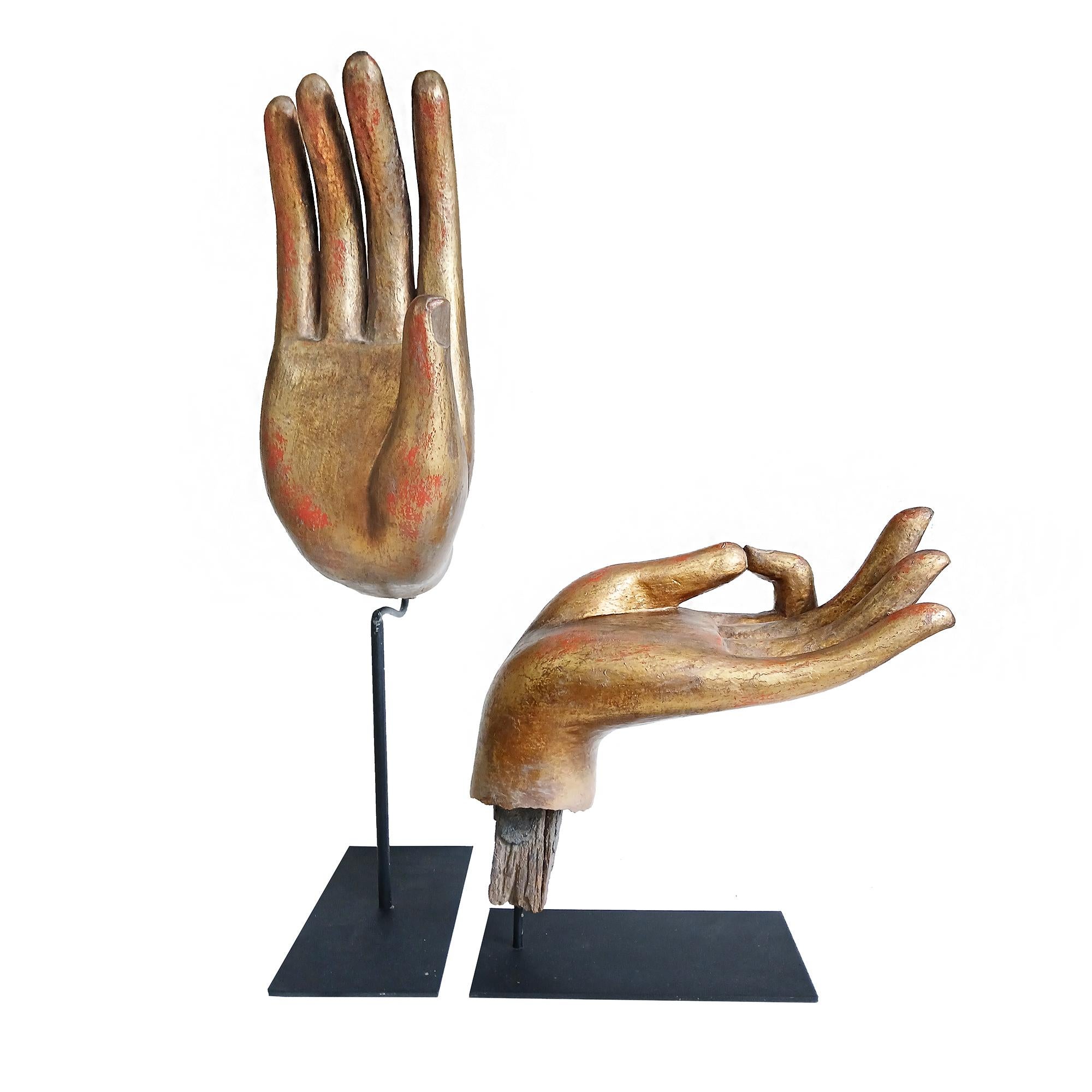 Deux superbes mains de Bouddha en bois, récupérées sur de vieilles statues. Fin du 19e siècle et début du 20e siècle. 

Polychromées avec des pigments dorés et rouges et montées sur des supports en métal noir spécialement fabriqués sur mesure,