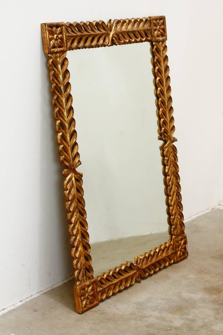 Impressive gilt carved wreath mirror by Christopher Guy Harrison for Harrison and Gil. Made in the French Louis XVI taste featuring a wreath design with large, carved rosettes in each corner. Stamped and numbered with a 