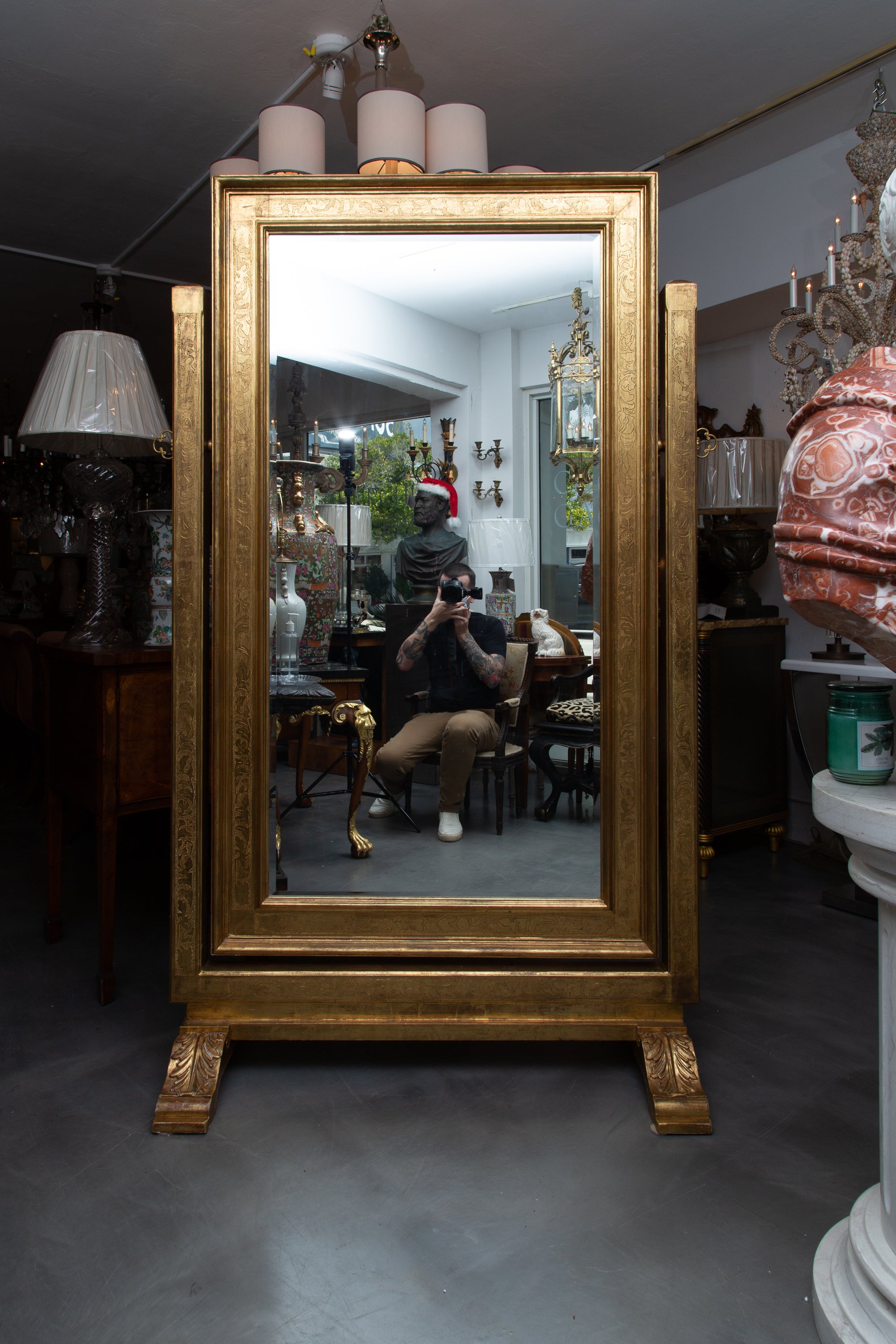 Impressive continental cheval mirror with a mild carved design and a gilt surface.