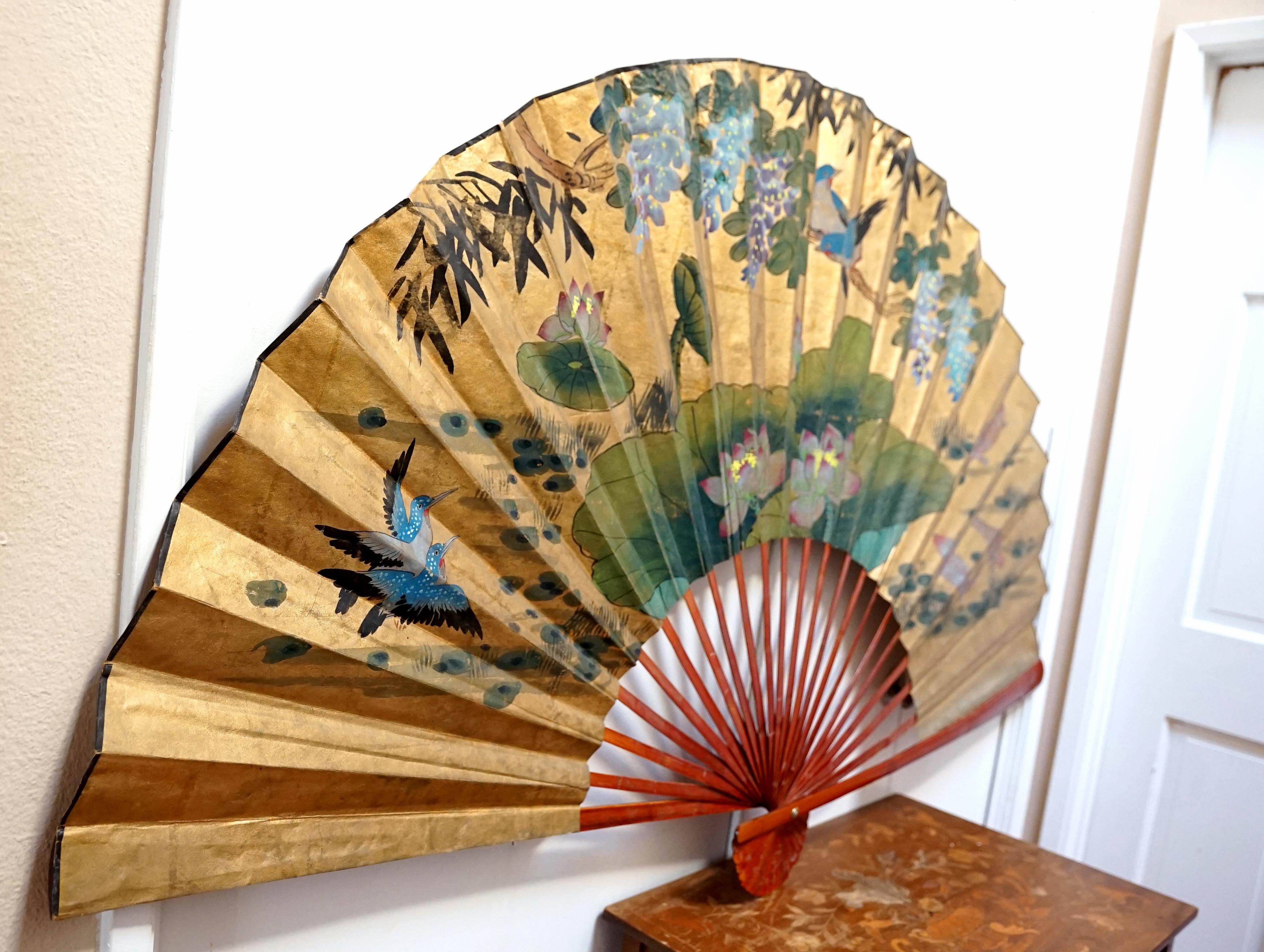 This hand painted gilt monumental folded Chinese Export fan is worth collecting. This is a vintage piece from the 1960s most likely. The fan is ready for installation with two threaded hooks on the reverse side. This makes a wonderful sculptural