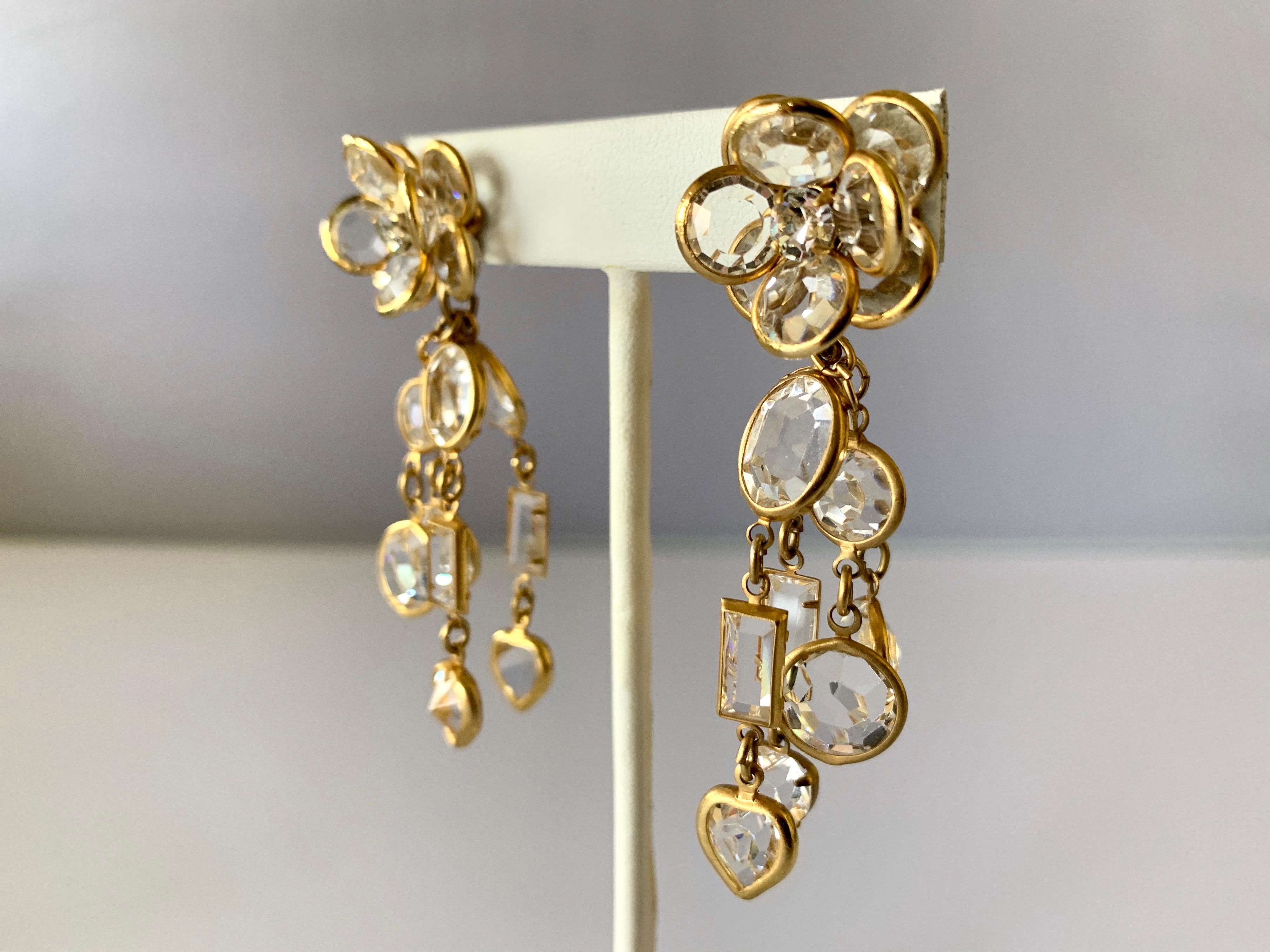 Vintage pierced statement earrings comprised out of gilt metal and clear faceted crystals. The earrings feature flowers with tassels that are accented with diamante rhinestones - made in France circa 1970.
