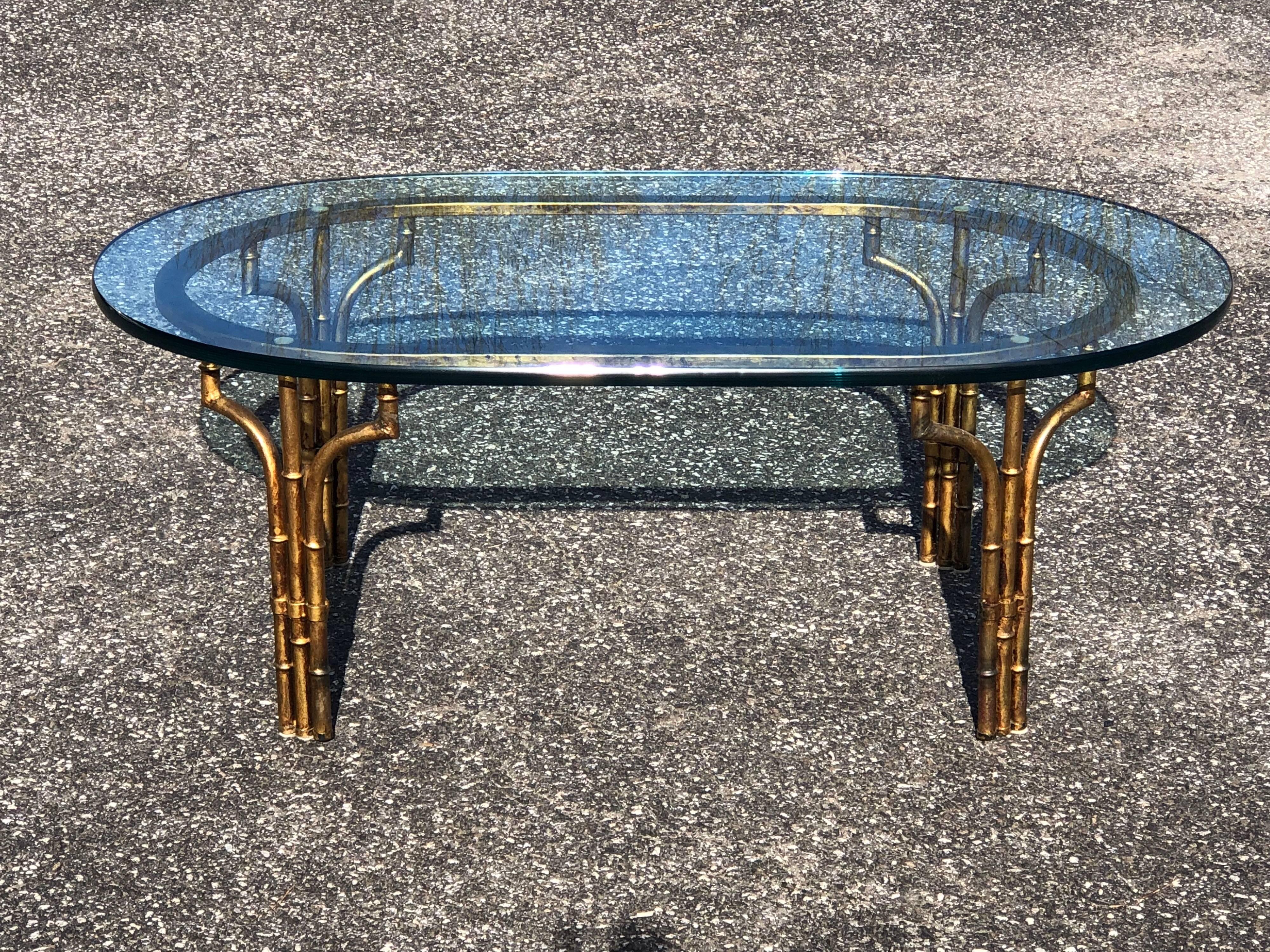 Gilt faux bamboo oval coffee table with very thick oval glass top. Elegant statement piece and the perfect smaller size for a smaller living room space. Please request more photos if needed.
The base alone measures . Stamped on underside of feet.