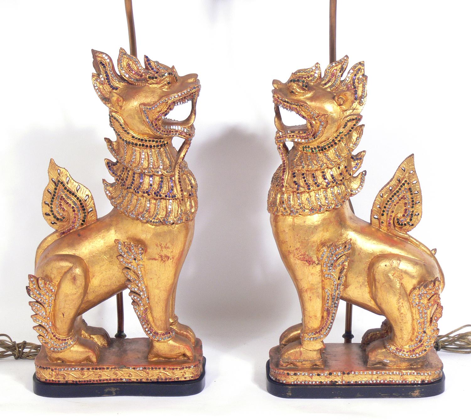 Pair of gilt Foo dog lamps, in the manner of Tony Duquette, circa 1940s. The foo dogs themselves probably originate from Thailand and may be much earlier than the 1940s when they were made into lamps. The price noted below includes the shades. They