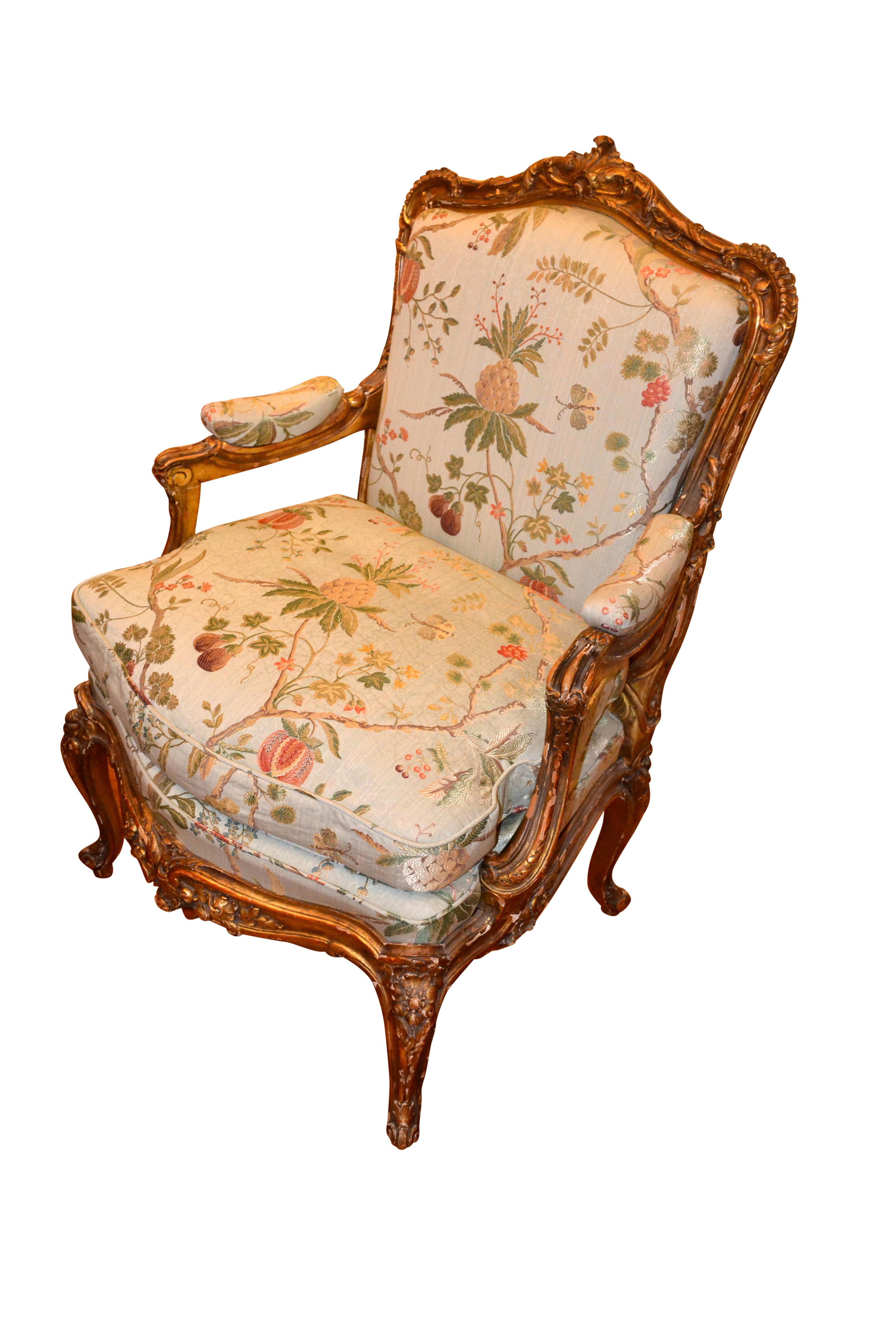 A superbly carved single Louis XV style open arm chair with overall deep crisp carving to the gilded beechwood frame, upholstered in light blue green Scalamandre silk floral fabric. Likely mid-19th century, French.