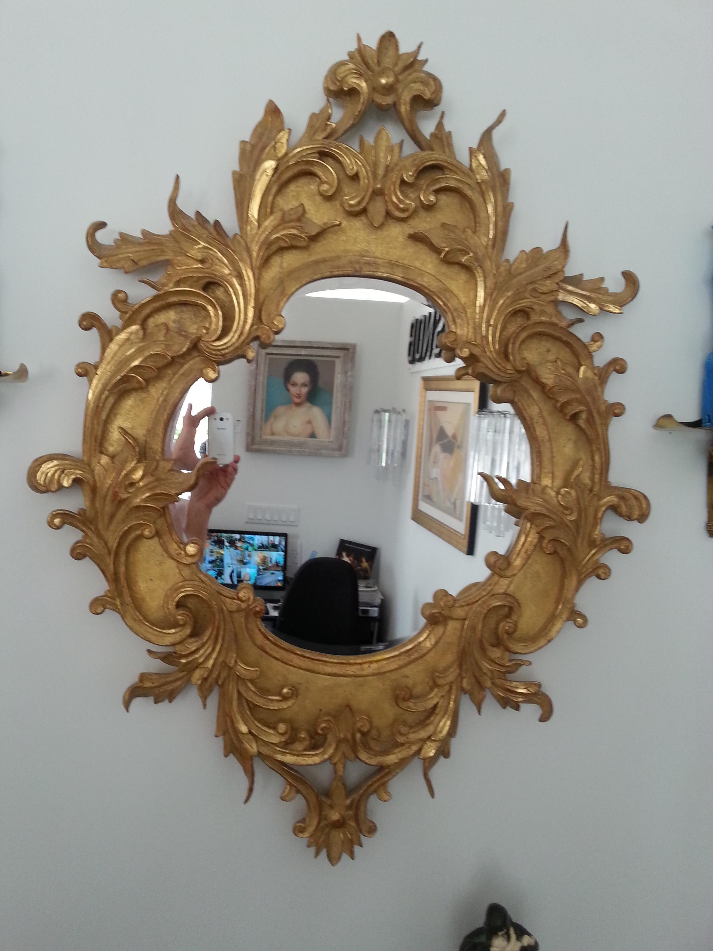 This stylish and chic late 19th century Italian gilt-gold mirror was acquired from a Palm Beach estate. The piece is finished in a soft gold and highlighted in parcel-gilt with a high finish, which catches the light beautifully.