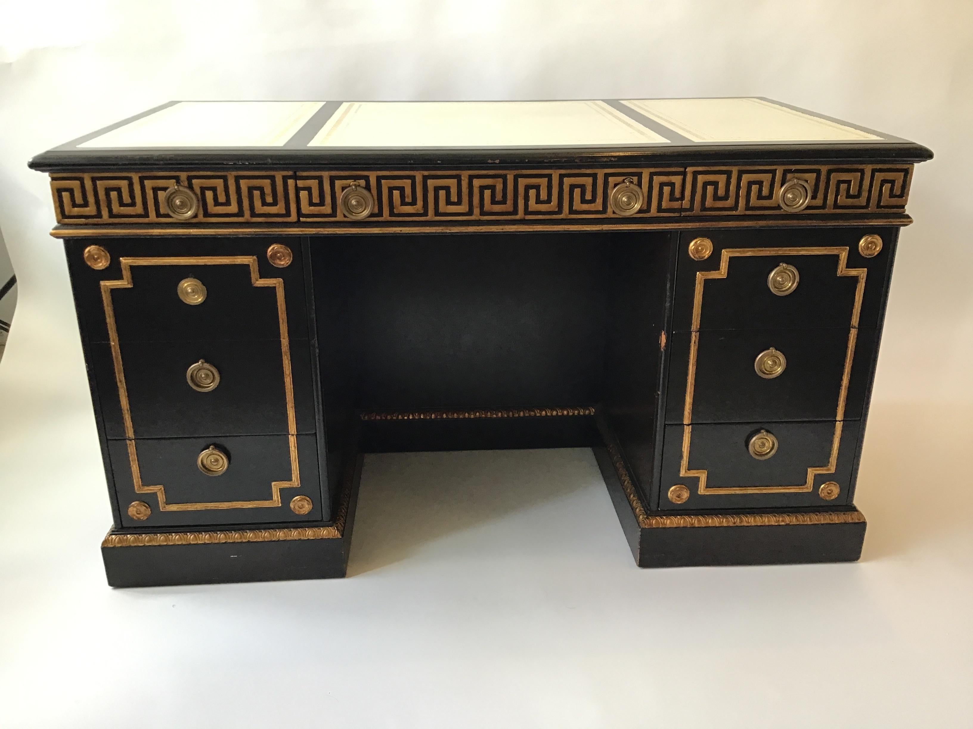Very well made desk, probably by Baker. Gilt Greek key desk. The finish is black stain. Finished back with shelf. Leather top with embossed Greek key. The drawers are Very deep, they’re the length of the desk. Bronze hardware.