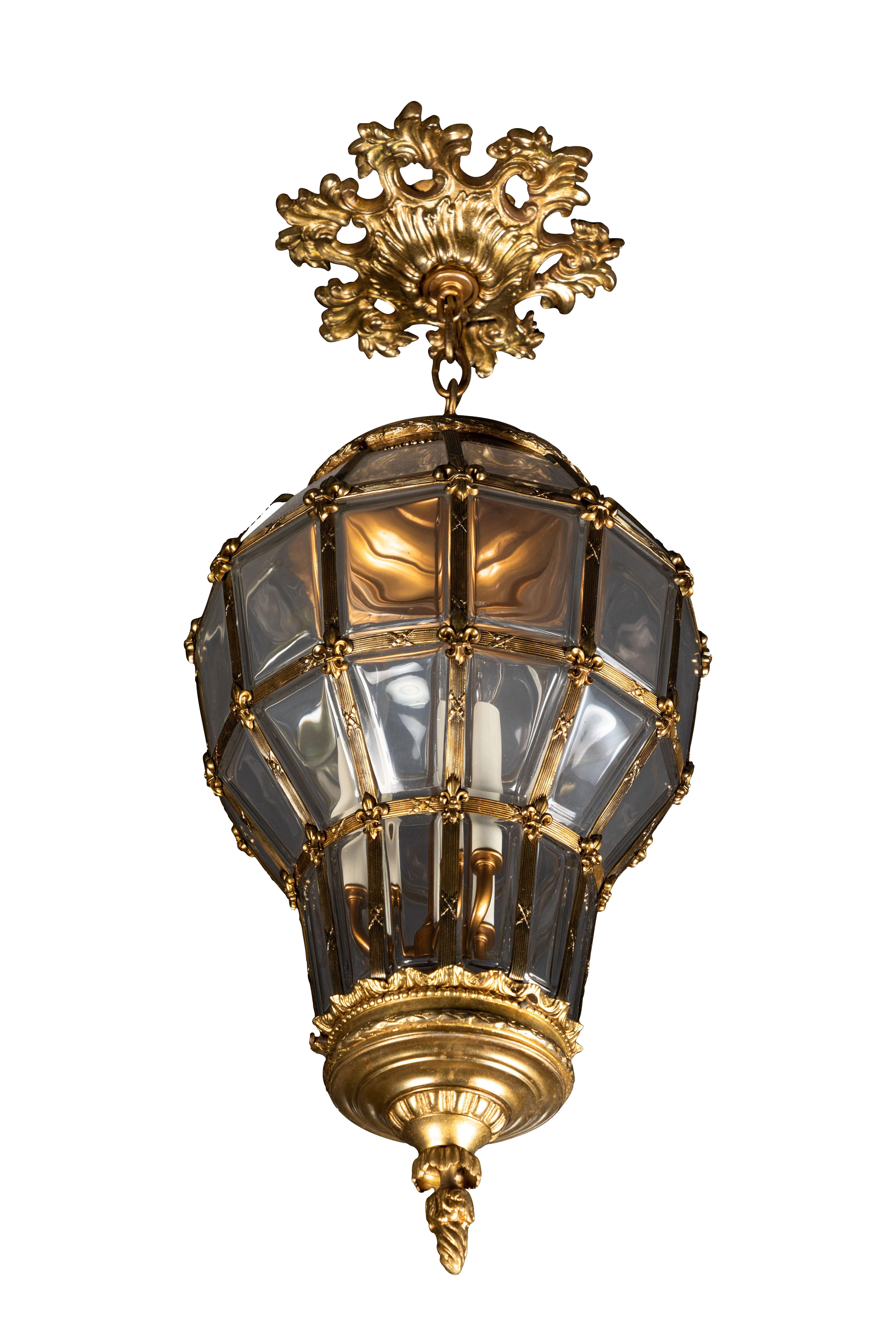 Large antique Louis XV style glass hanging lantern with ceiling escutcheon, gilt metal, and glass. The lantern takes three candelabra bulbs. The drop is on a variable chain.
