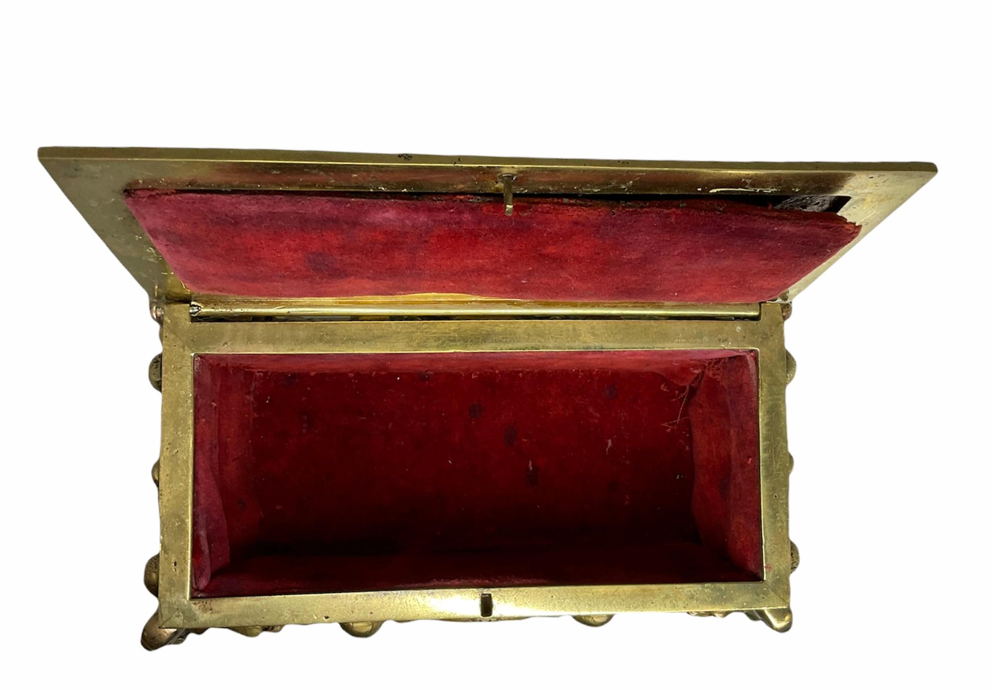 Il s'agit d'une boîte à bijoux/décorative rectangulaire en bronze doré repoussé. Il présente dans la partie supérieure du couvercle une scène de Don Quichotte chevauchant son cheval alors que des moutons courent à côté d'eux. Des chérubins tenant