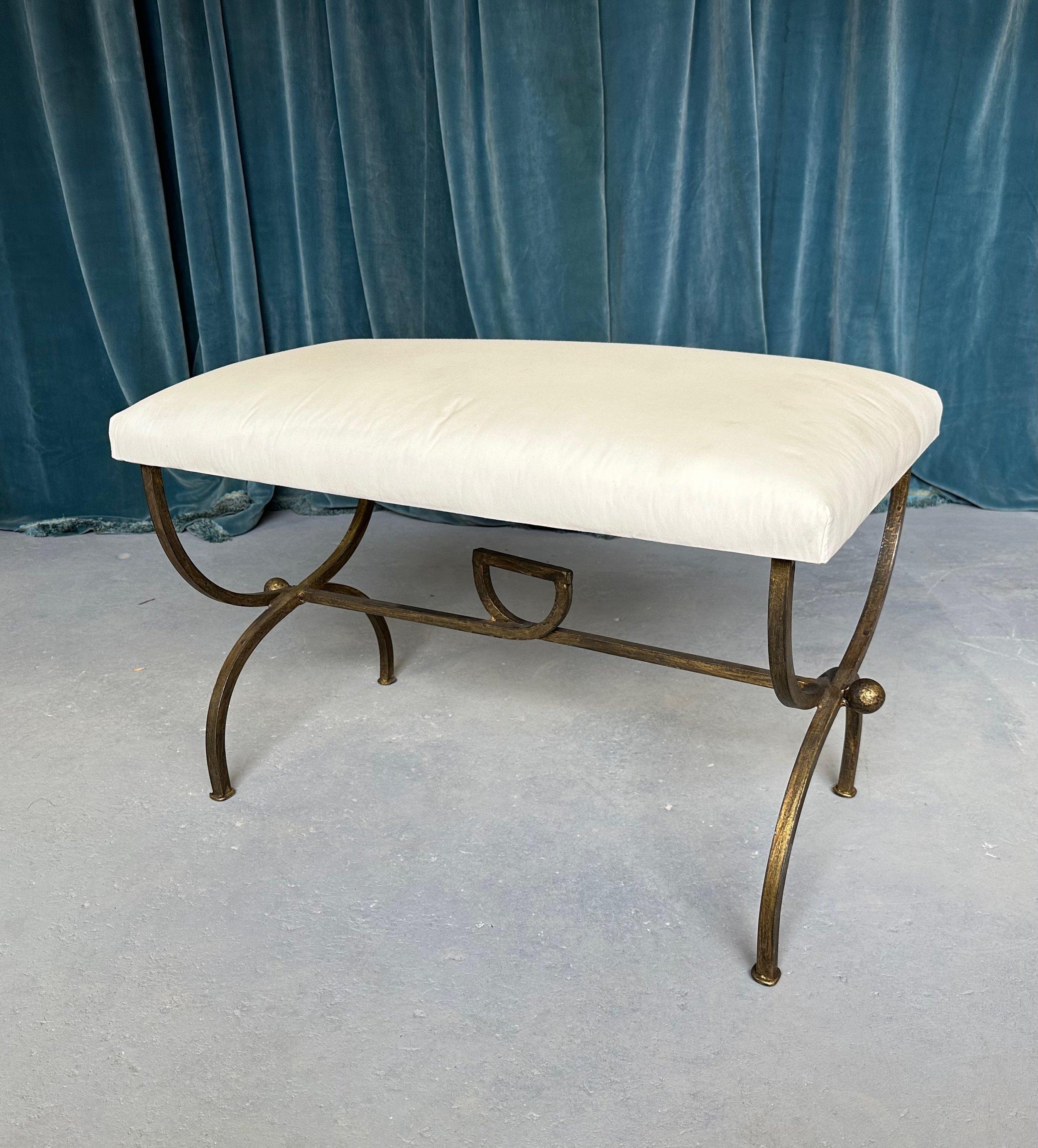 An elegant recently made iron bench with gracefully curved legs and a central stretcher that features a decorative central loop and spheres at the ends. Handcrafted by expert European artisans using traditional iron-working techniques, this lovely