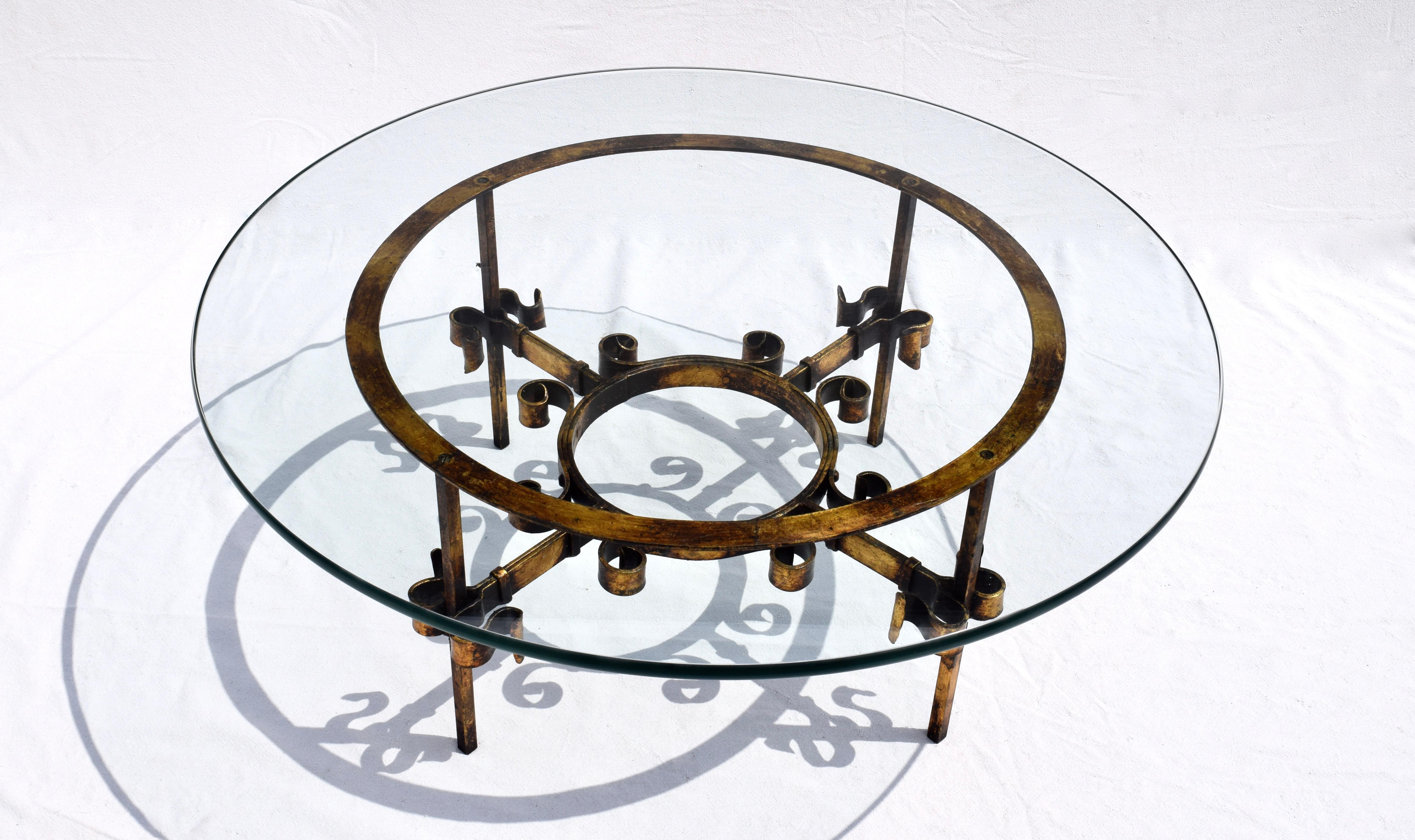 Hand wrought iron parcel-gilt cocktail table with glass top designed in the manner of Gilbert Poillerat.
Table with glass top is 16.3/8