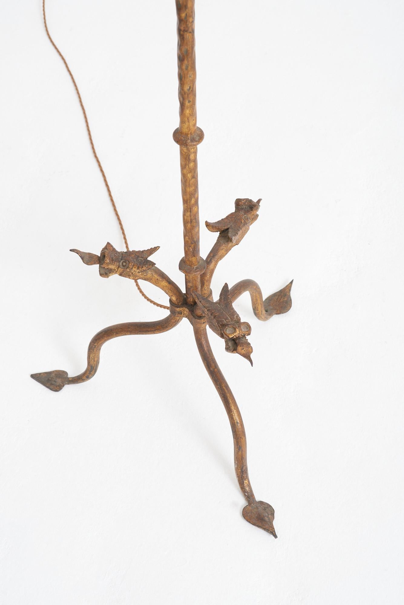 A gilt and forged iron floor lamp, the tripod base with satyr heads.
Spain, mid 20th Century
With the shade: 162 cm high by 48 cm diameter
Lamp base only: 139 cm high by 48 cm diameter