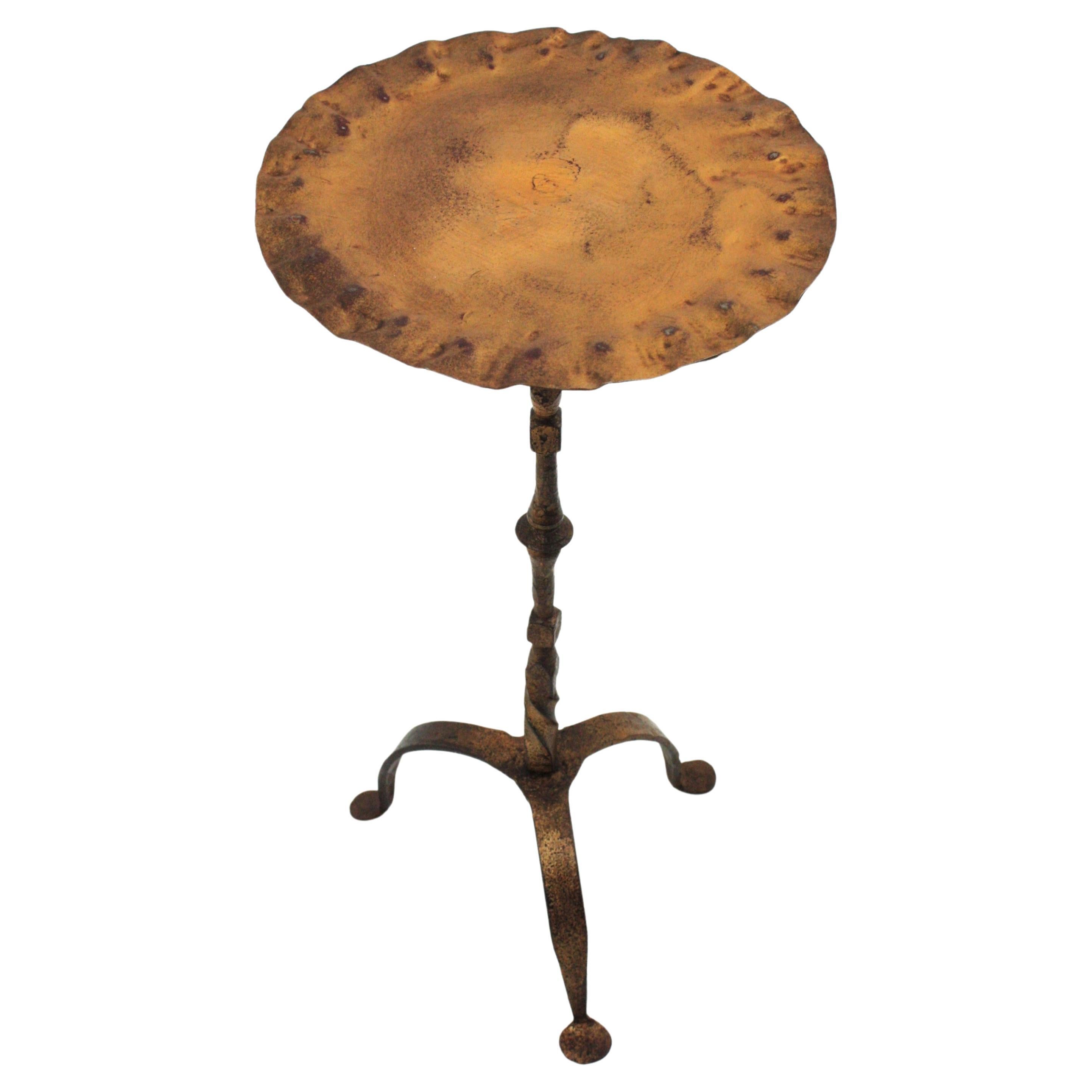 Spanish Drinks Table / Side Table / Martini Table in Gilt Iron with Wavy Top, Spain, 1940s-1950s
A gold gilt hand-hammered iron drinks table with wavy edged top standing on a tripod base.
This handcrafted pedestal table has a round top adorned by