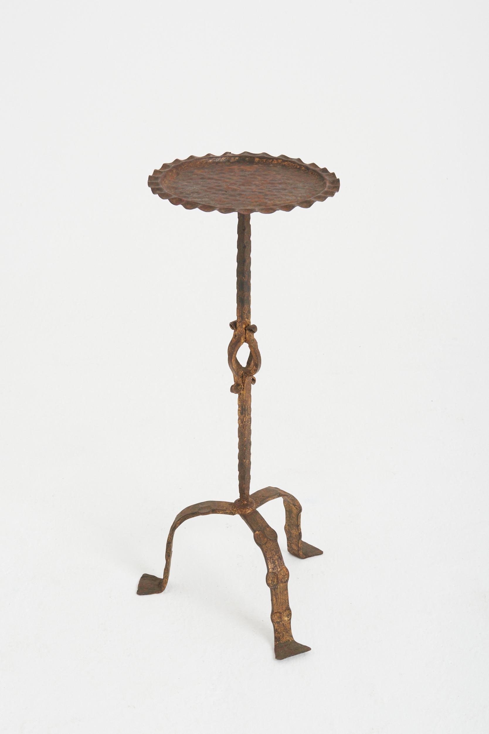 A wrought and gilt iron martini table.
Spain, mid 20th Century
63.5 cm high by 24.5 cm diameter.