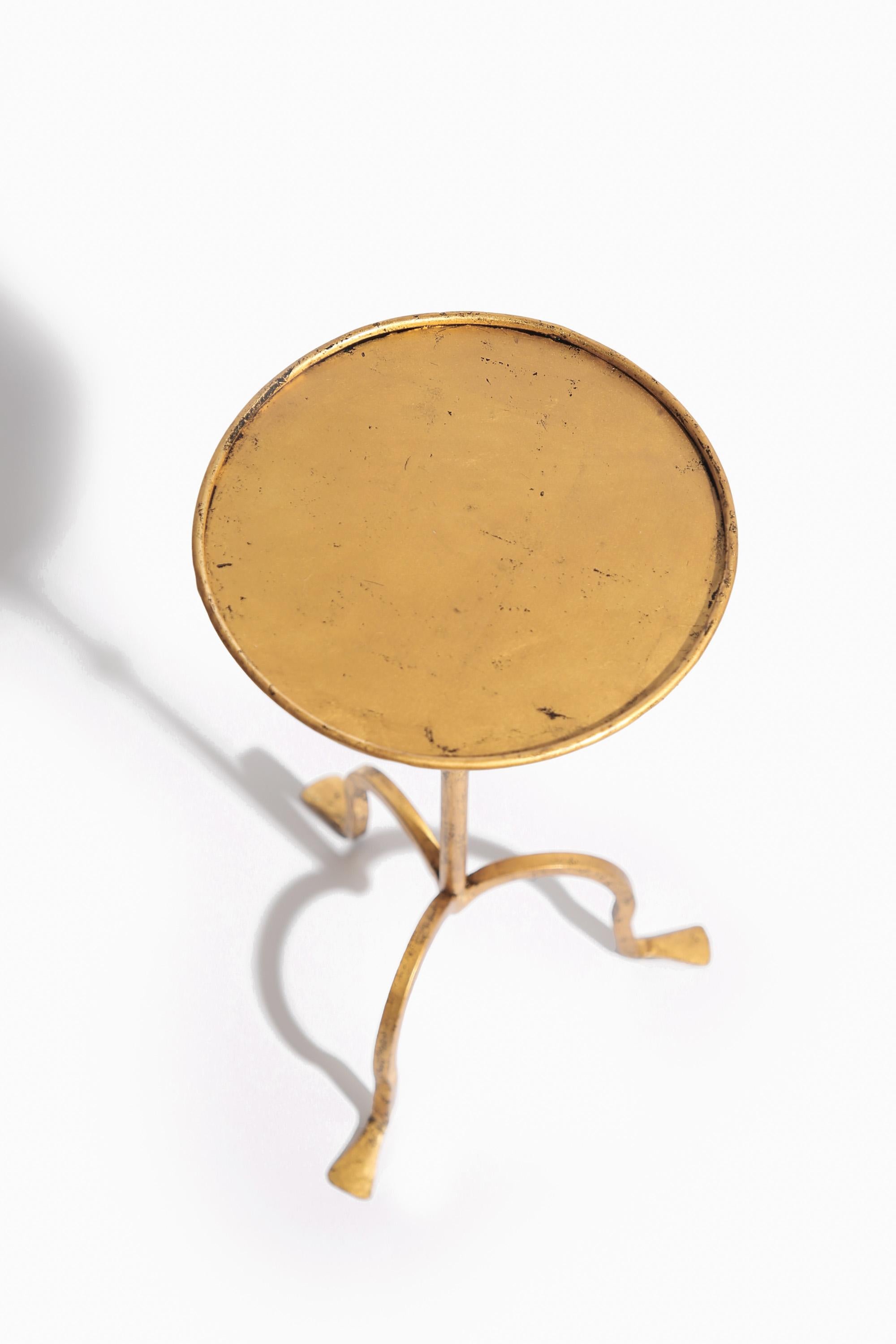Table à martini en fer doré, fabriquée à la main en Angleterre.

La table est forgée à la main par un forgeron hautement qualifié et finie en feuille d'or 23,5 carats avec une finition vieillie.

Disponible en stock ou sur commande avec un délai de