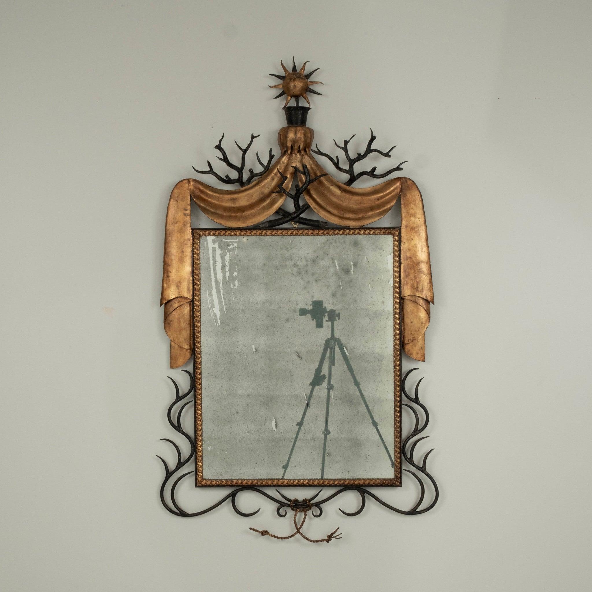 Miroir en fer doré du 20e siècle présentant un travail de fer forgé à la main formé de branches, de vignes, de ficelles, de draperies et d'un ornement en forme de soleil.