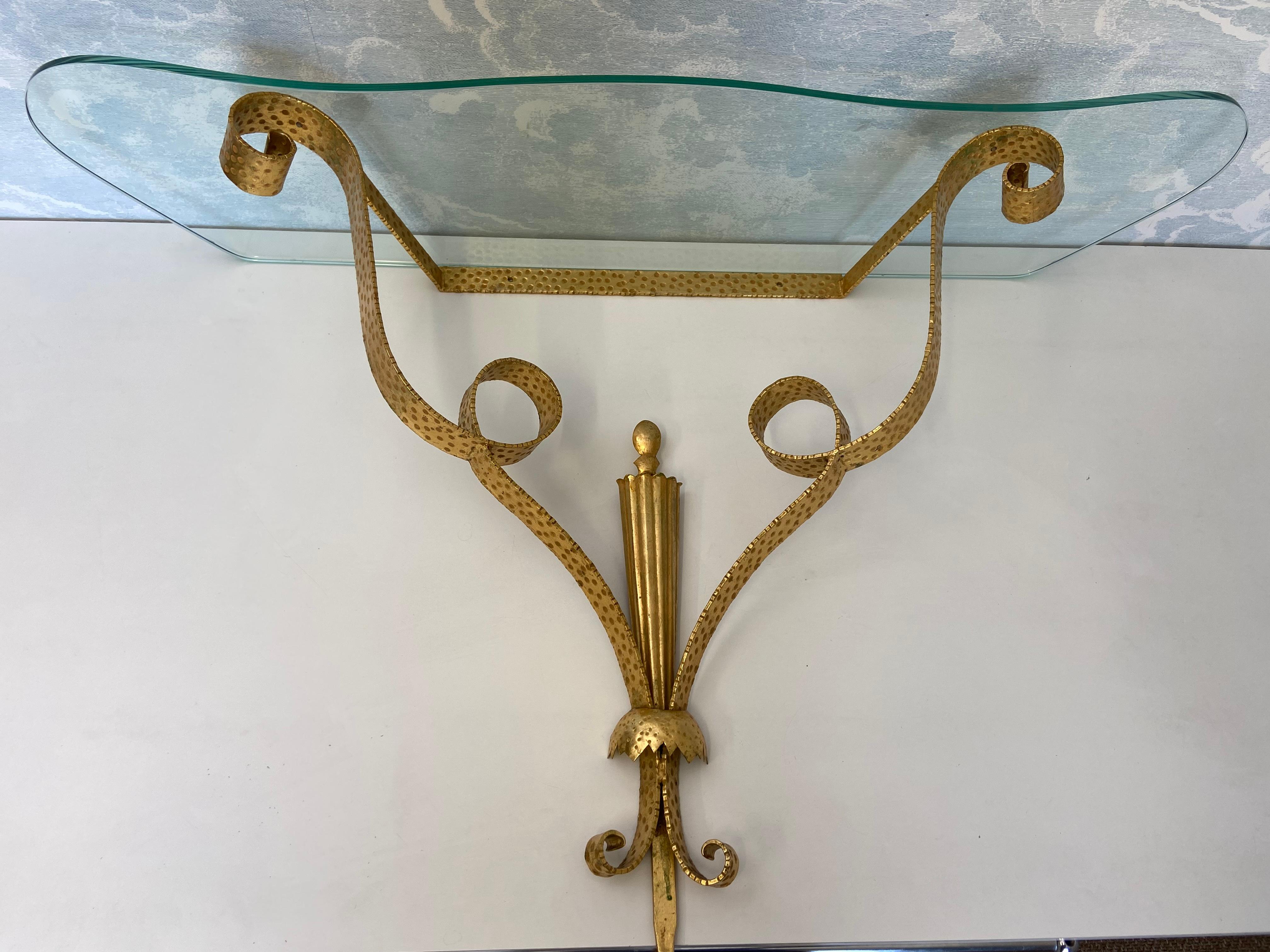 Dieser reizvolle wandmontierte Konsolentisch des einflussreichen italienischen Möbeldesigners und Architekten Pier Luigi Colli stammt aus dem Turin der 1940er Jahre.

Das Gestell besteht aus vergoldetem, gehämmertem Metall, das zu Looping-Bändern