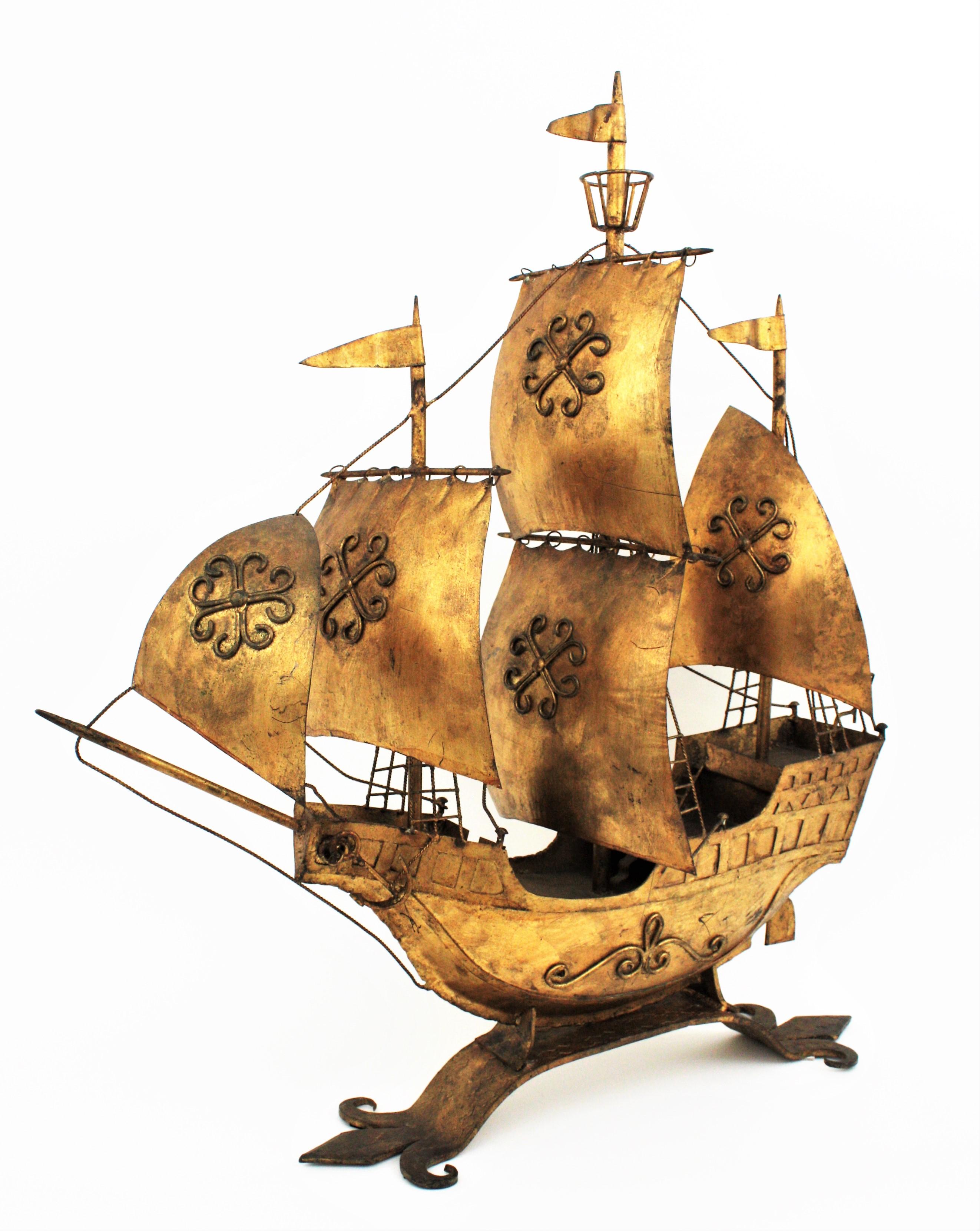 Outstanding large sized gilt wrought iron Spanish caravel boat or galleon sculpture. In the style of Gilbert Poillerat designs.
This sailing ship sculpture was handcrafted in Spain at the mid-20th century period. The ship stands up on a