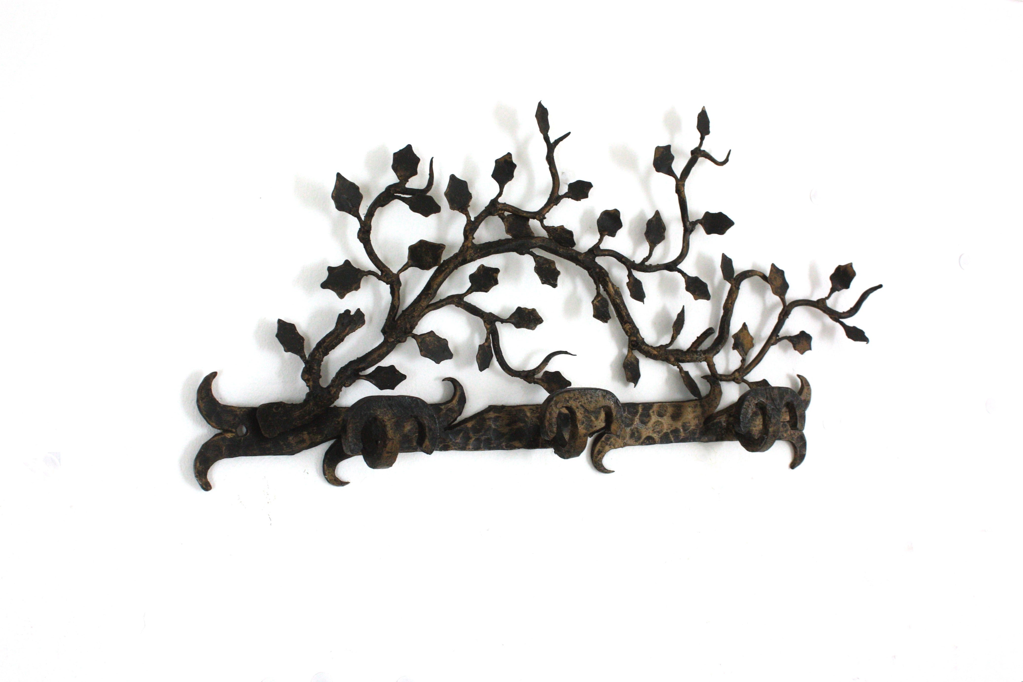 Naturalistischer Wandgarderobenständer aus handgeschmiedetem Eisen mit 3 Haken, Spanien, 1950er Jahre
Seltener Fund.
Dieser Garderobenständer wurde vollständig aus handgeschmiedetem Eisen hergestellt. Er ist mit einem Inkrustationsmuster aus Zweigen