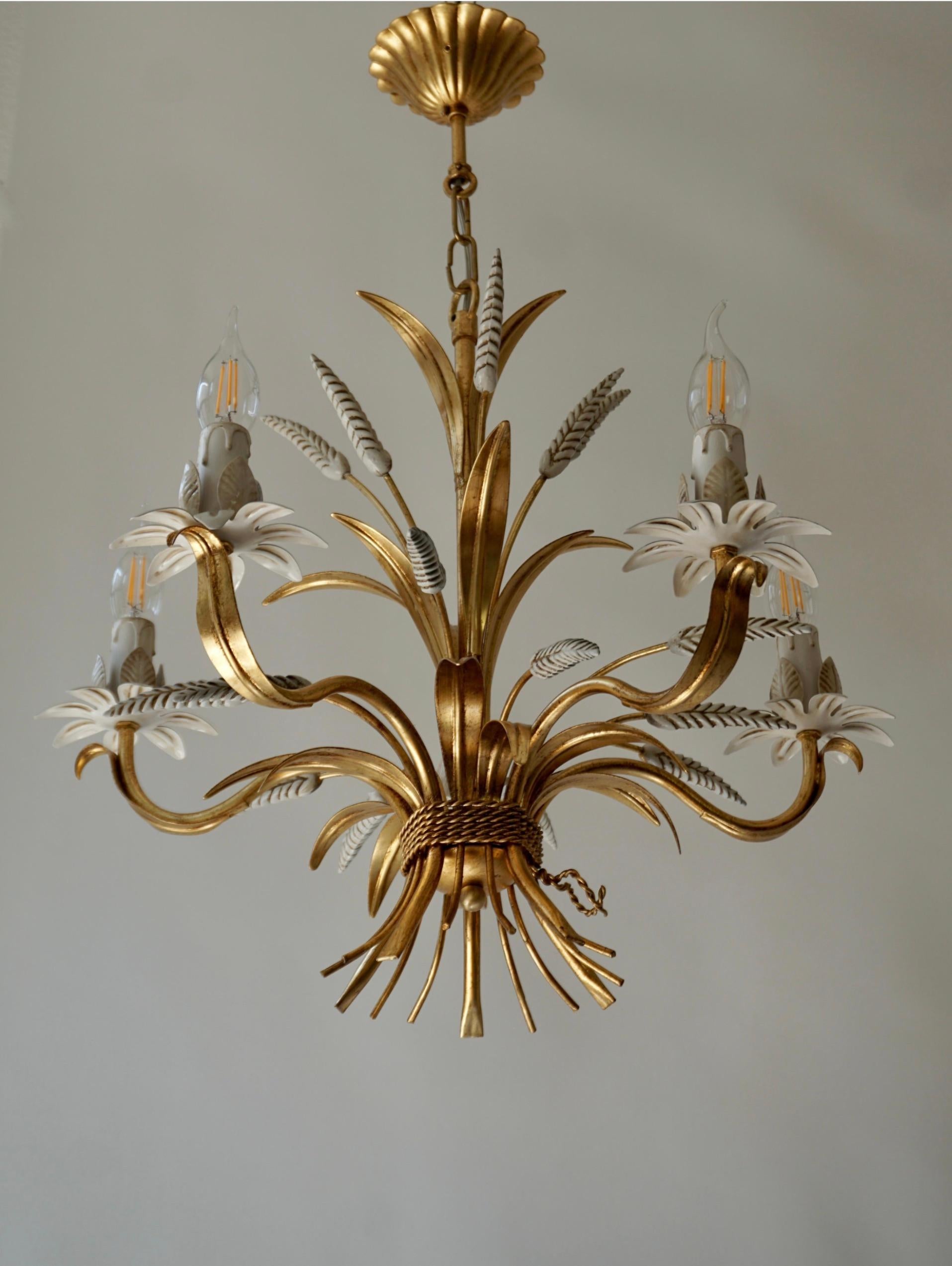 Gilt Italian Floral sheaf of wheat five-light chandeliers Coco Chanel  

Hollywood Regency in style, this chandelier inspired a Coco Chanel with sheaves of wheat has five branches with teardrop lamp holders.This tole pendant lamp has a warm antique