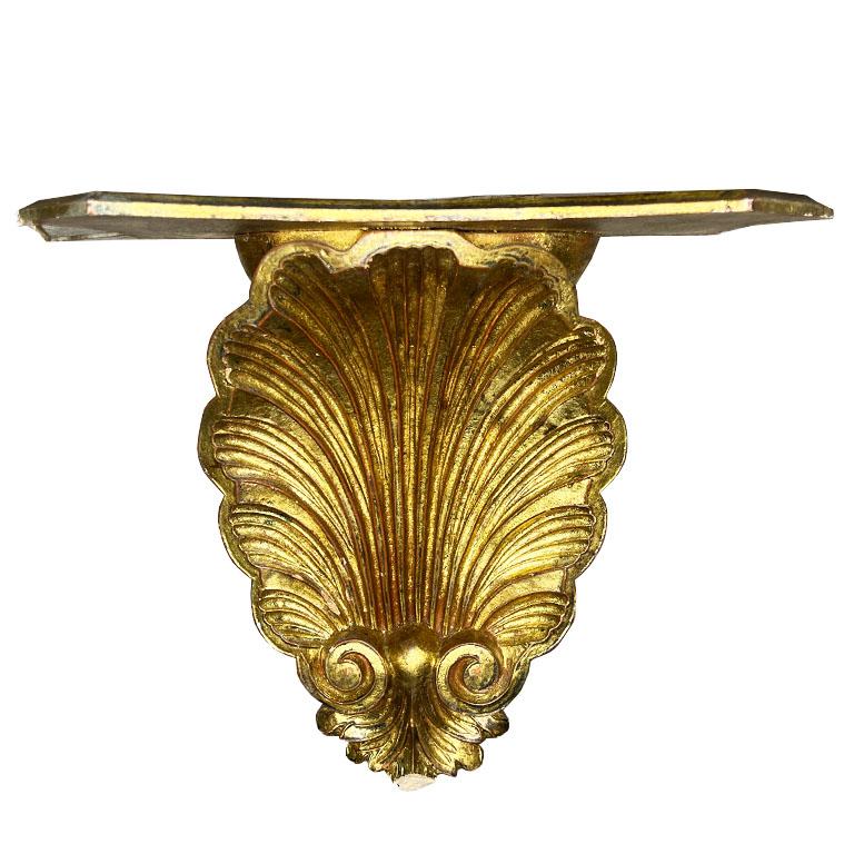 Elevate your space with this exquisite vintage Italian Florentine giltwood wall shelf. It features a regal rococo shell motif with gold leaf. This decorative piece exudes timeless elegance and sophistication. The intricately carved details,