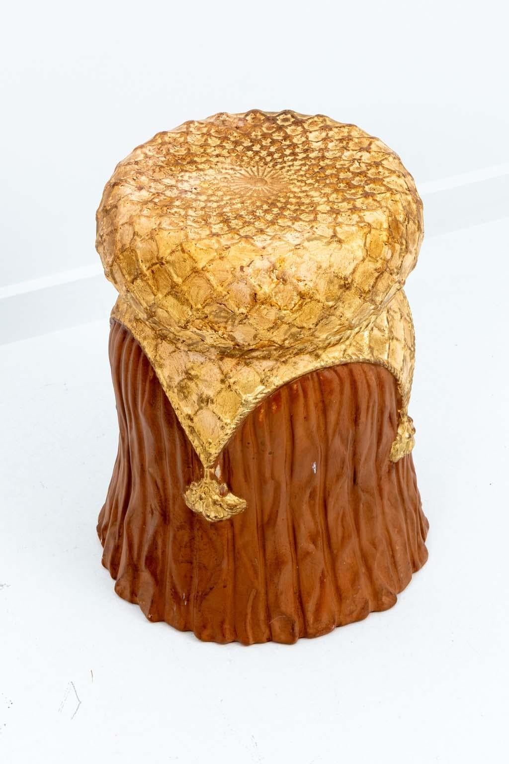 A gilt Italian tassel from Hollywood Regency garden seat or stool. Suitable for indoor use only. The form designed to resemble draped fabric or a large tassel. Marked made in Italy on underside.
