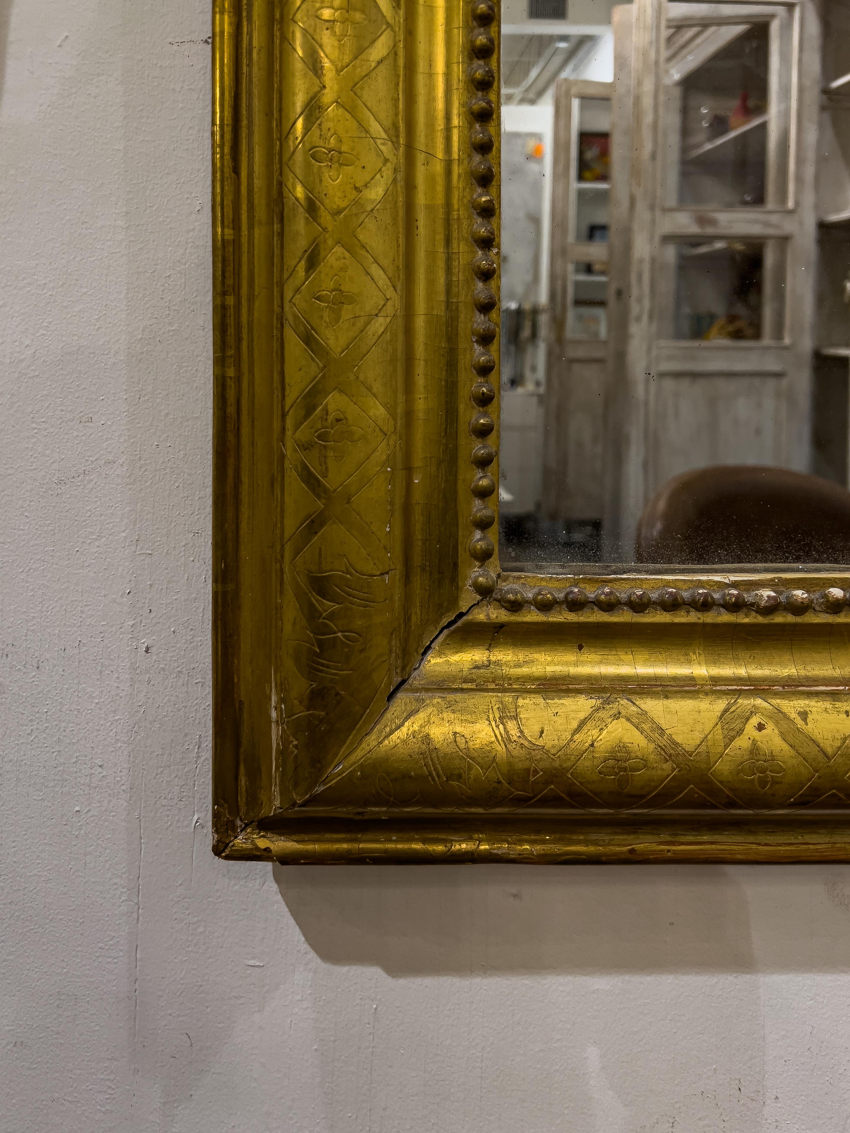 This is a beautiful gold leaf gilt Louis Philippe mirror that was made in France at the end of the 19th century. 

The rounded corners are typical for French Louis Philippe mirrors. This one has a more rare 