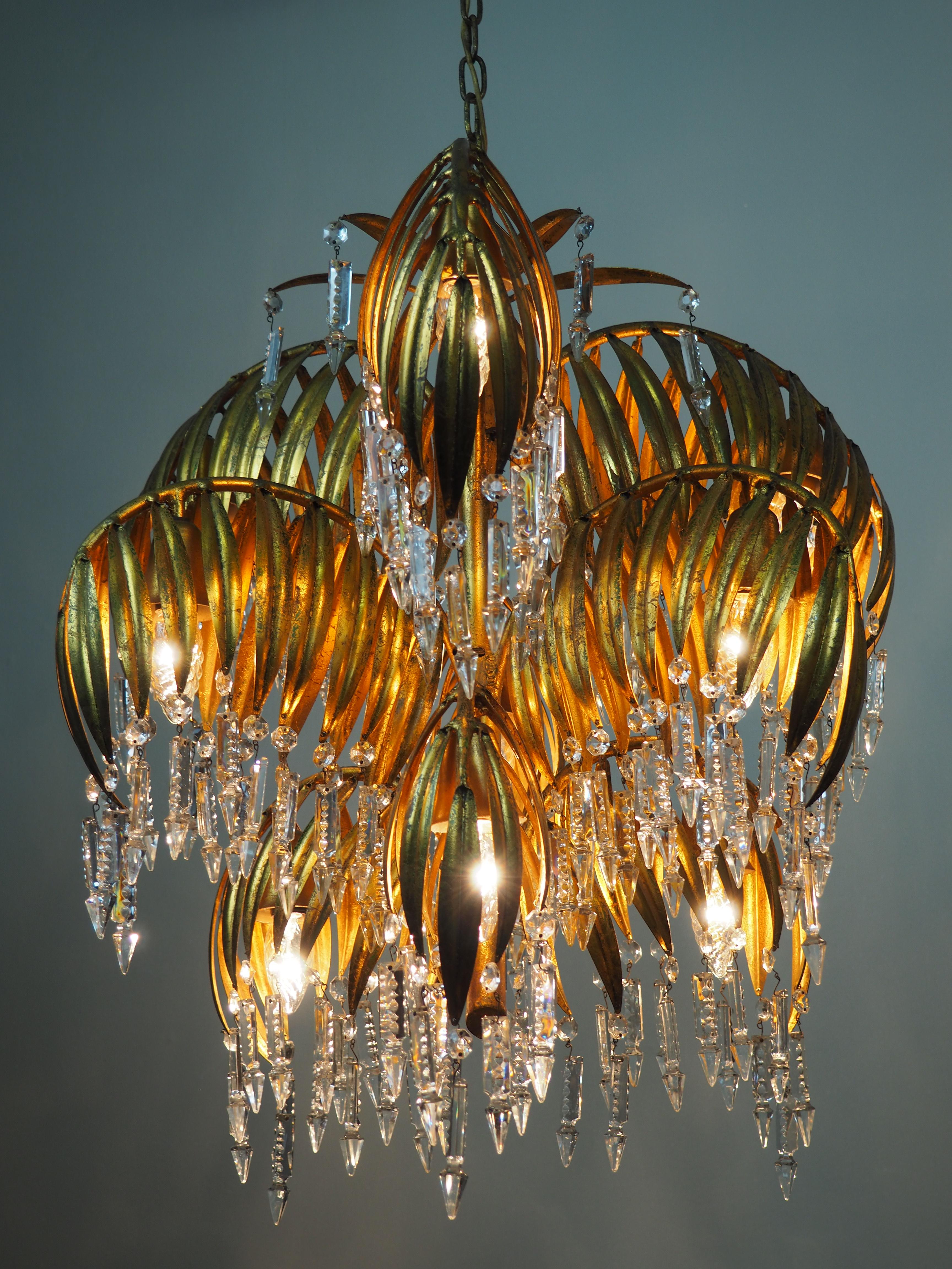 A beautiful and rare palm tree chandelier attributed to Hans Kögl, Germany, circa 1970s.
This wonderful nine-light chandelier is made of gilt metal and decorated with crystals.
Dimensions: W 25.59 x H 25.59 (51.18 inkl. chain and canopy)
Socket: