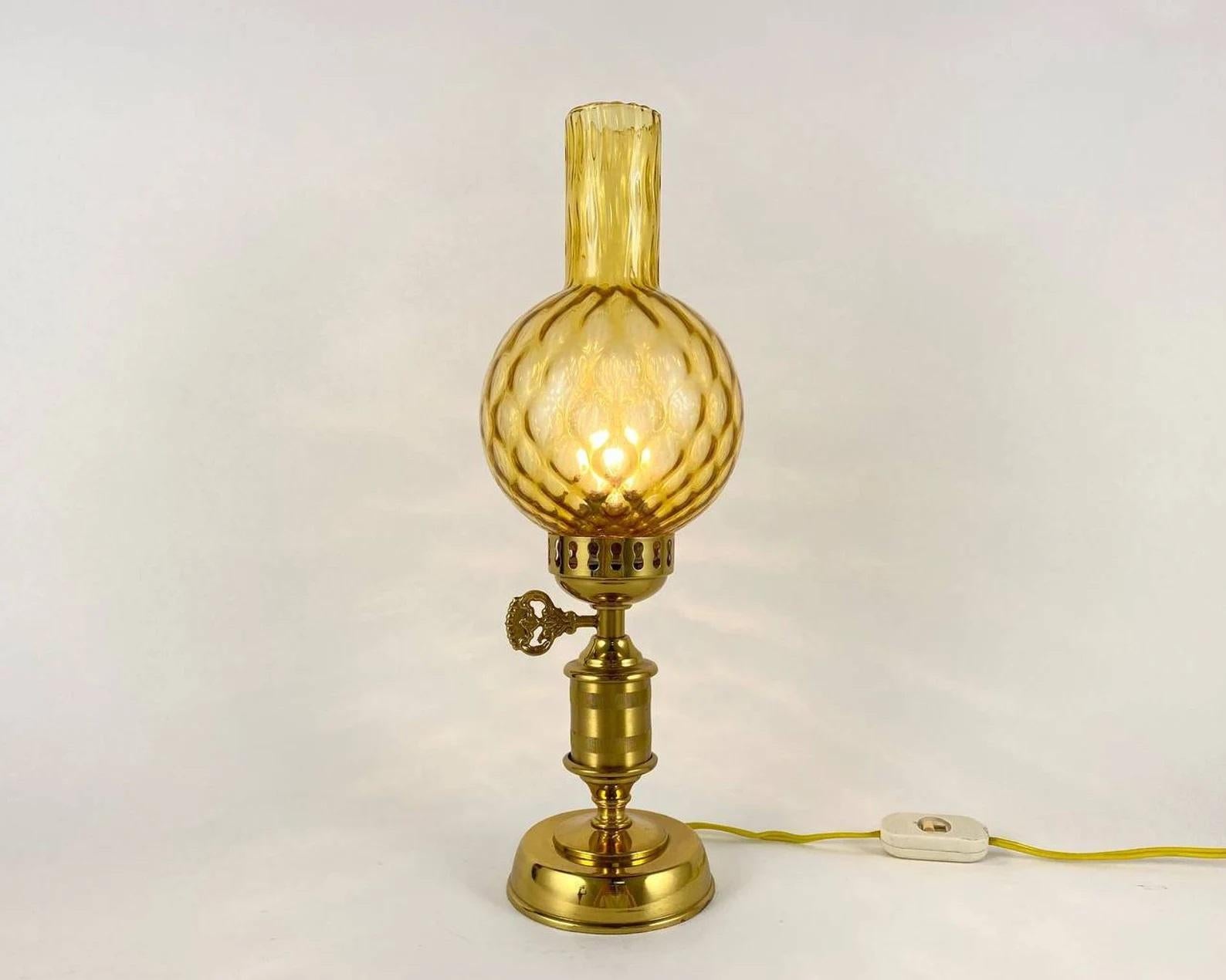 Absolutely charming vintage electric lamp made of gilded metal and the corresponding glass lampshade - sculpted in the style of kerosene lamps, made in 1980s in Germany.

The first kerosene lamp was designed by the Polish inventor Ignacy