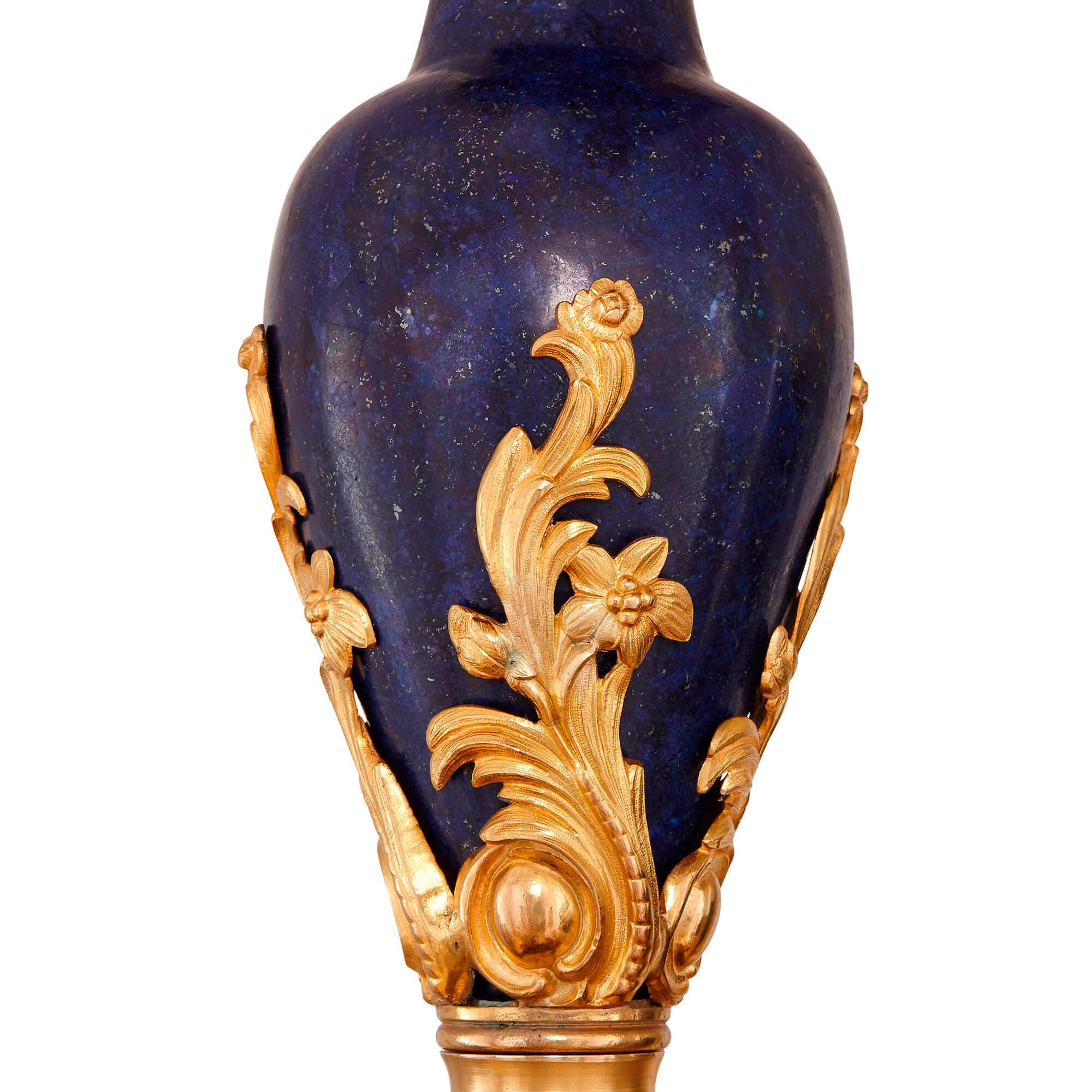 This grand chandelier has been beautifully crafted from precious materials. The body of the piece is veneered in the blue gemstone, lapis lazuli, and is further ornamented with gilt foliate patterns. The chandelier dates originally from the late