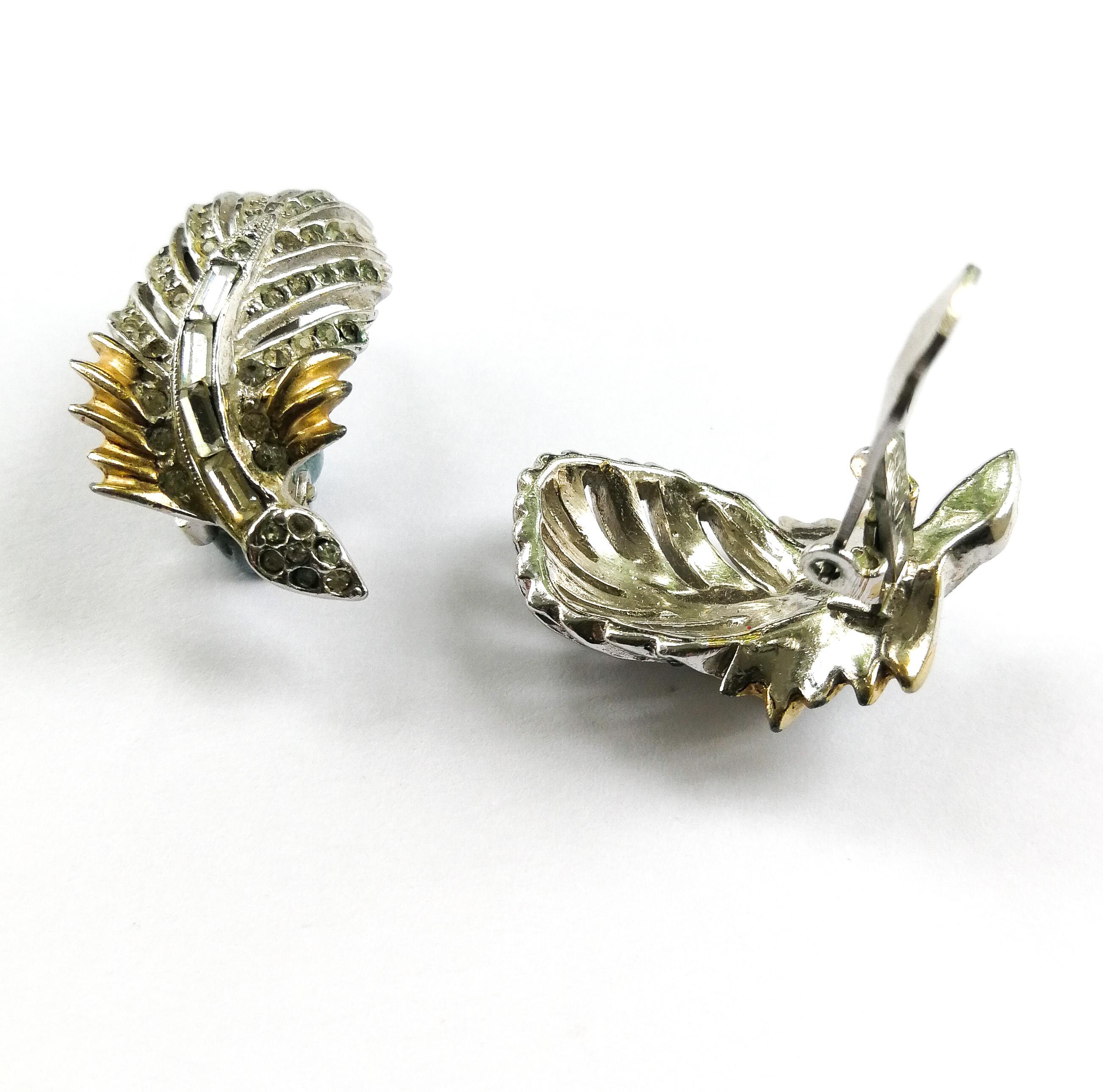 A  charming and attractive pair of earrings, in the form of a 'feather', made from clear pastes and gilded and silvered metal, from Reja, in the 1940s. With a mixture of baguette and round pastes, these are set in two coloured metals, the feathering