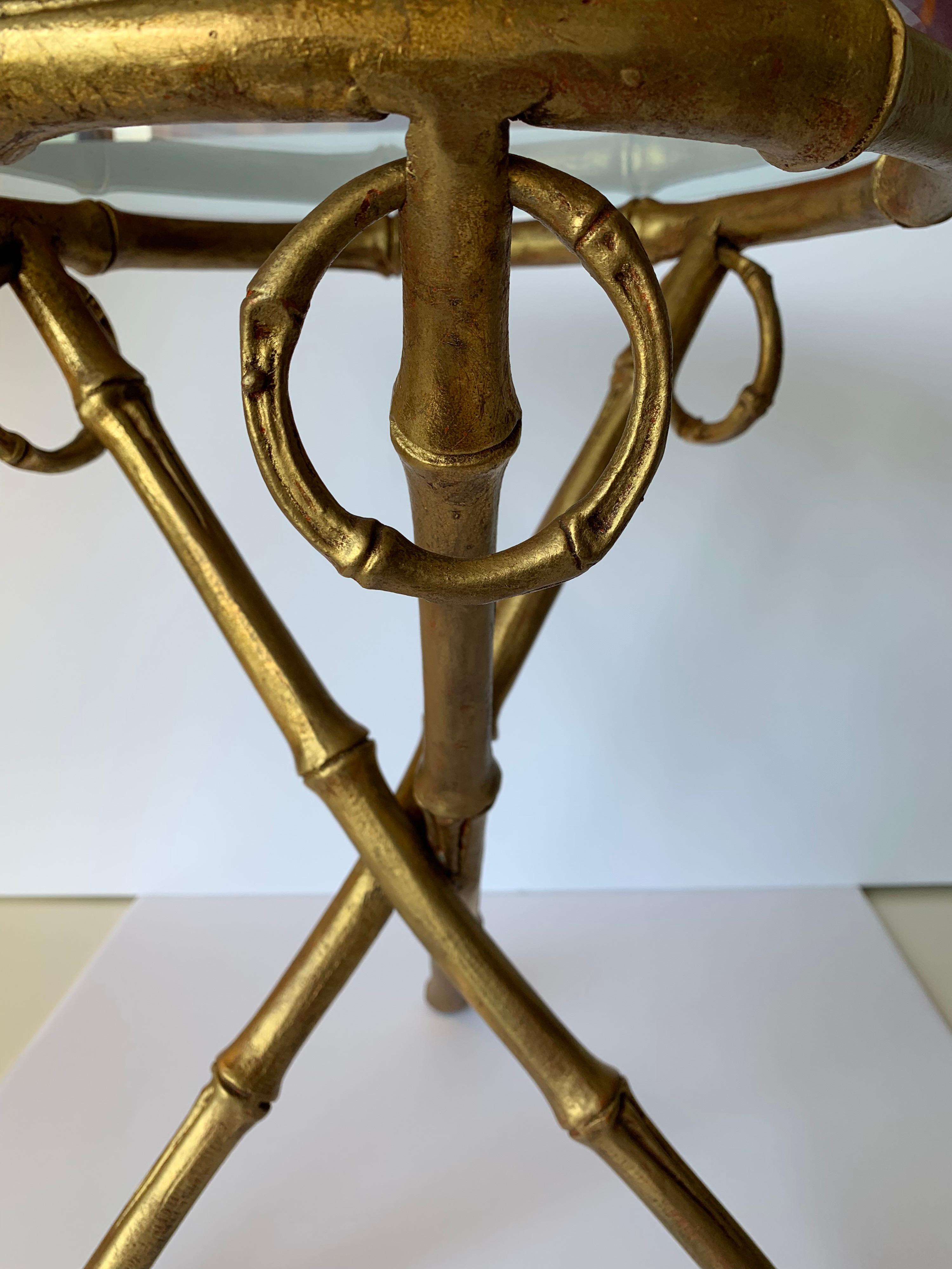 1960s gilt metal faux bamboo tripod style round accent table. New clear beveled glass top is 14” diameter.