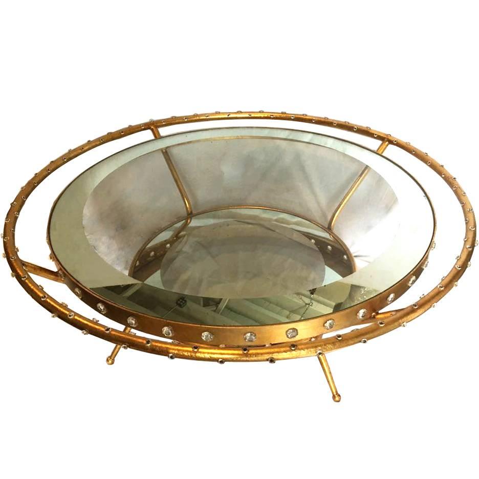 A circa 1960s French gilt metal coffee table with encrusted crystals on body, and two mirrored shelves.

Measurements:
60