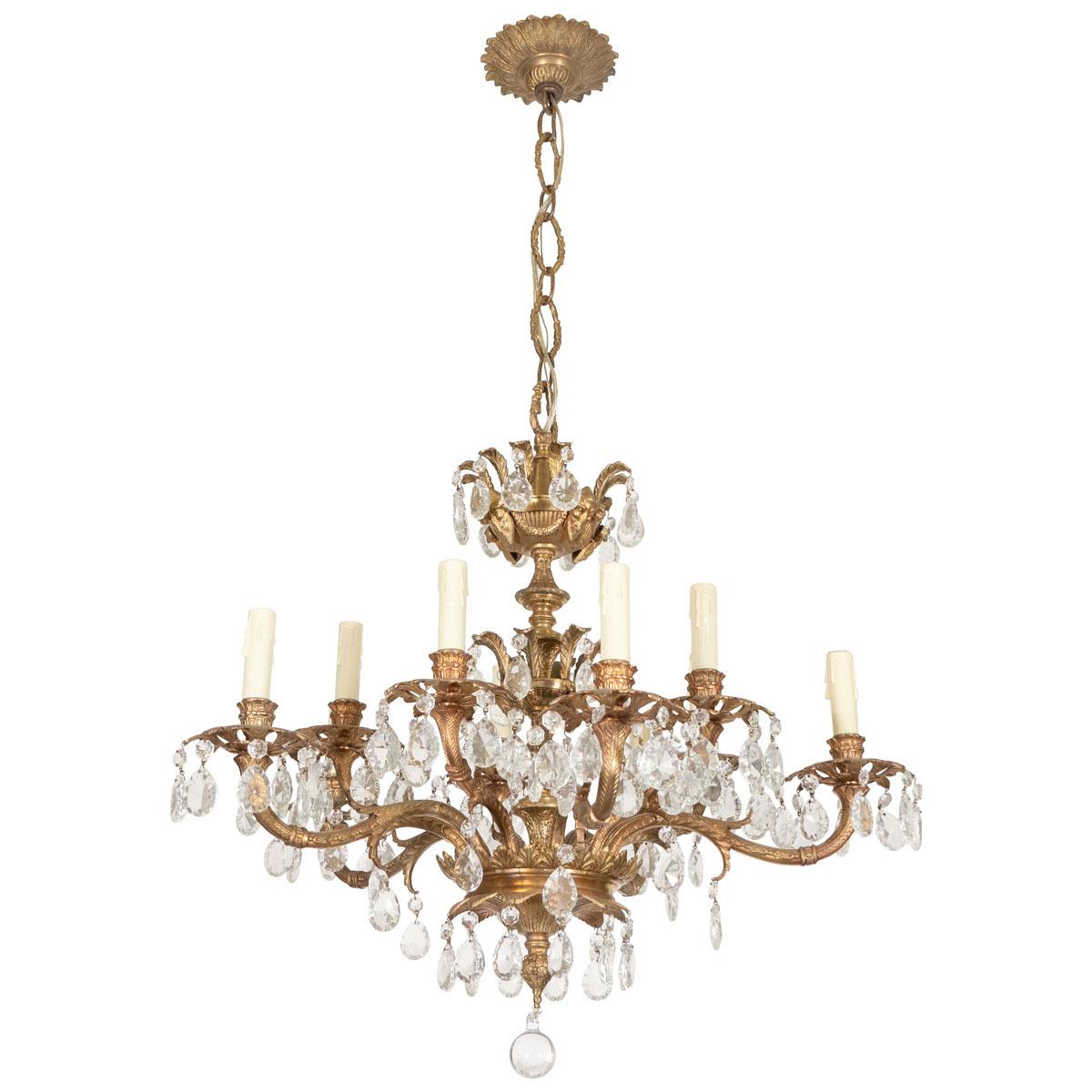Gilt metal crystal drop chandelier with intricate classical foliate motif.