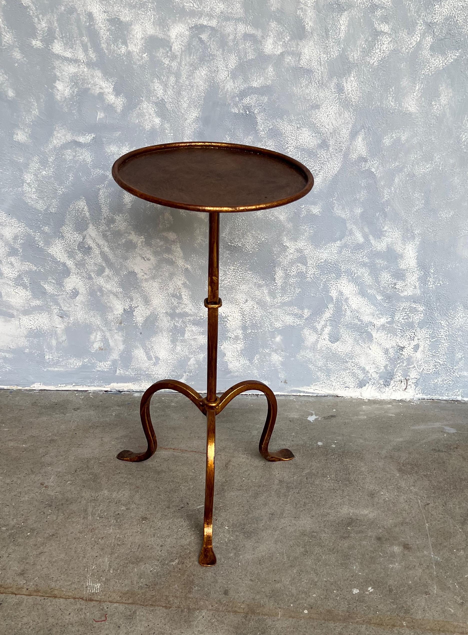 An elegant gilt iron drinks table on a tripod base. The original finish is a hand applied gold patina with red undertones. These tables are wonderfully adaptable as they can be moved around as needed for an extra drinks table.

Spanish, 1950s. Very