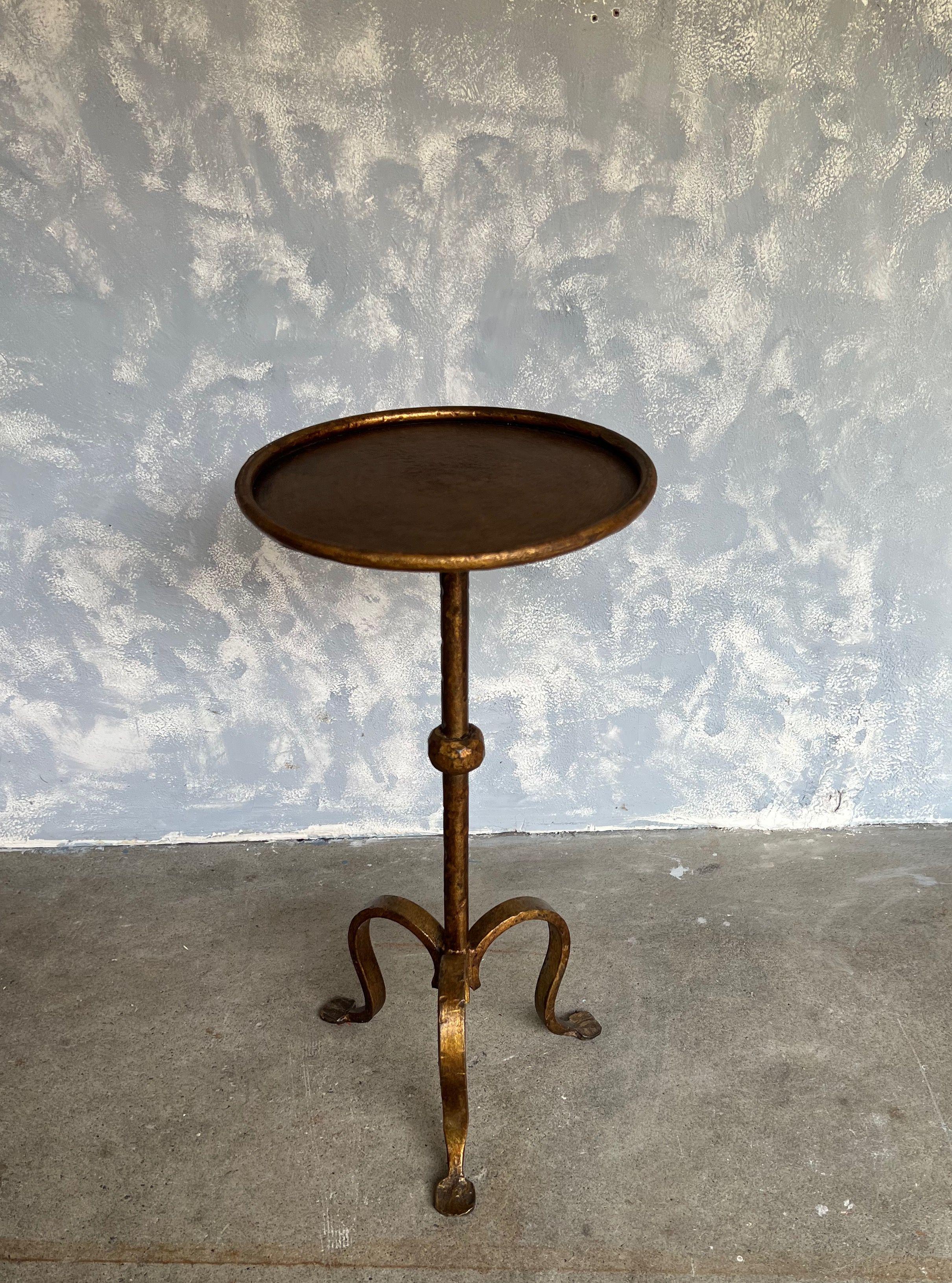 Small gilt iron and metal end table with a tripod base and a central ball detail on the hammered stem. Perfect for a drink, it can easily be moved around as needed. The original finish shows several under layers of black and red making for a rich