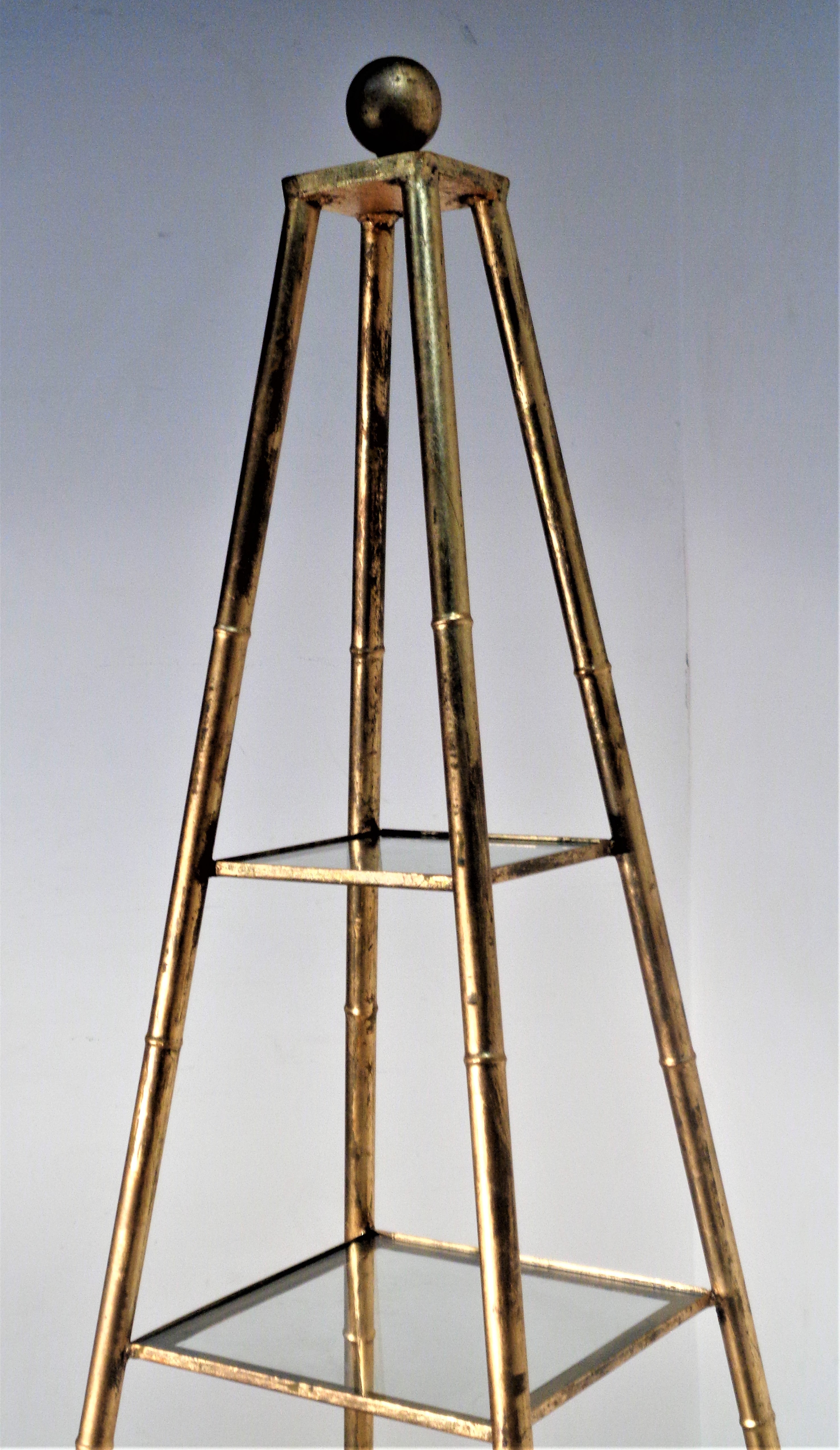 Faux bamboo gilt metal obelisk form etagere with four removable graduated size glass shelves / large gilt wood ball finial at top / raised on four gilt wood ball feet. Overall beautifully aged original gilded surface. Made in Italy, Circa 1960. This