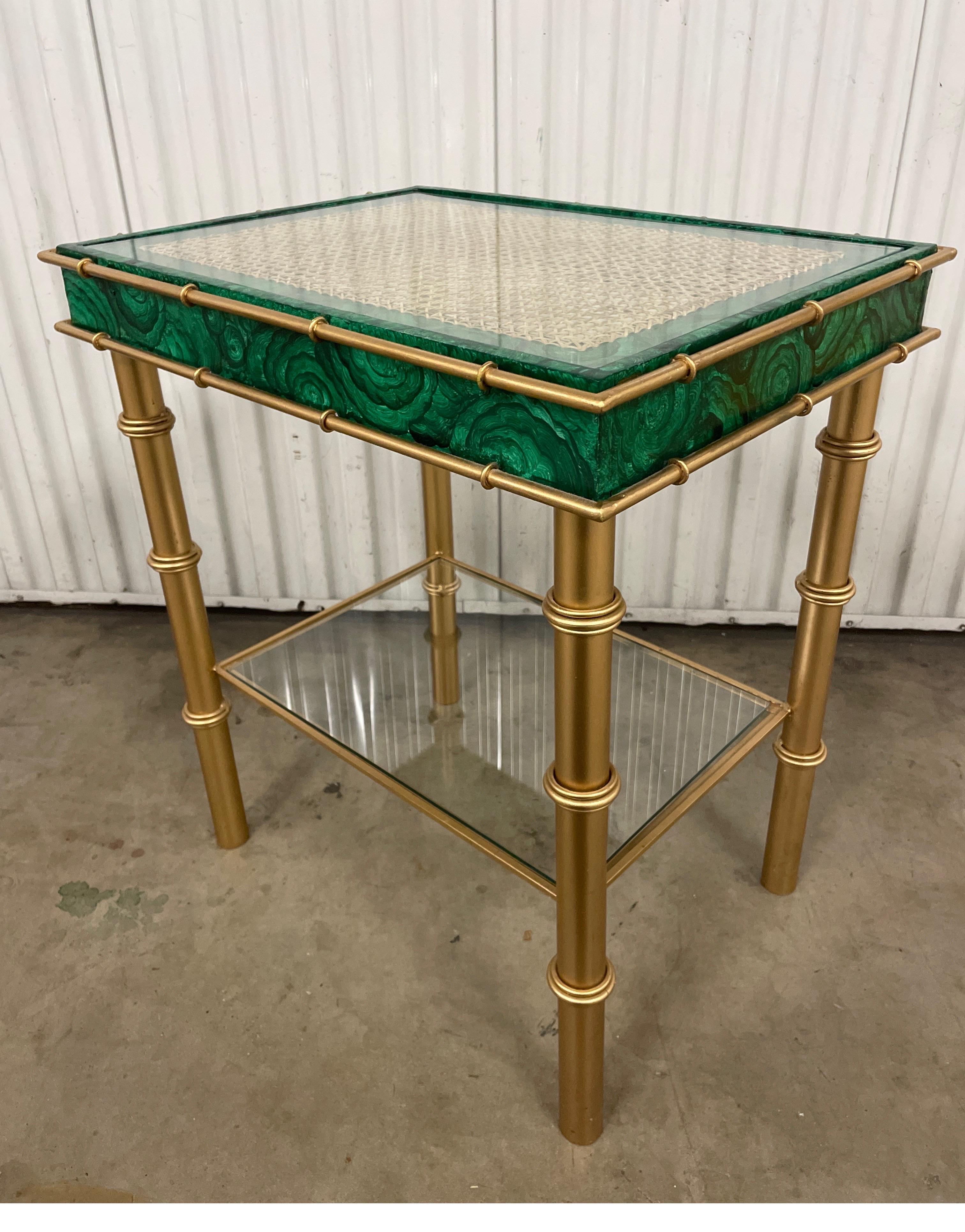 Table d'appoint à deux niveaux en malachite peinte à la main et en métal doré. L'étagère du haut est en verre sur canne et l'étagère du bas est en verre seul. Une paire est disponible.