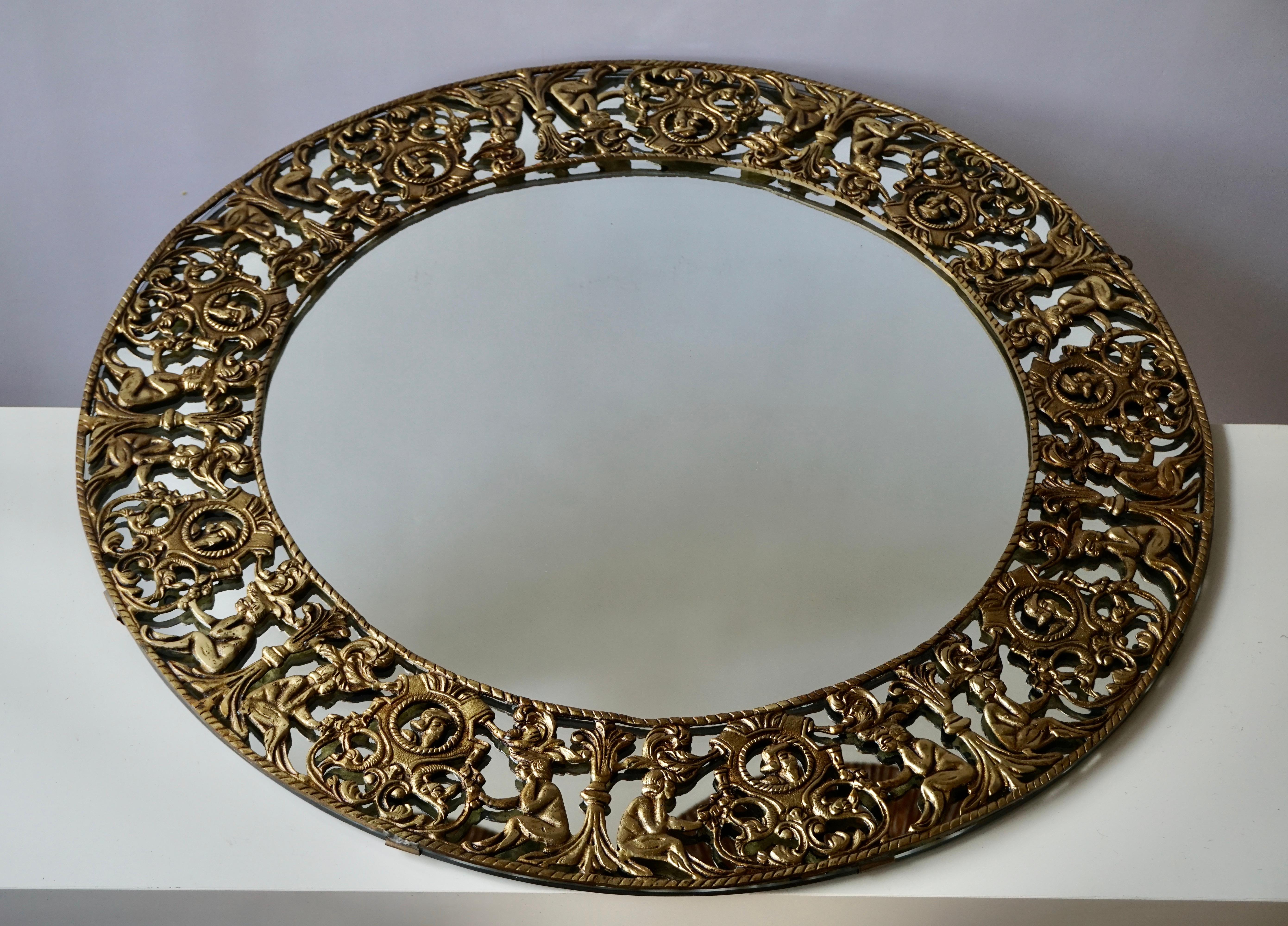 Beautiful large handcrafted gilt iron sunburst mirror. Italy, 1960s.The wall mirror has figural and leaves surrounding a central round glass. 
Overall diameter: 77 cm 
Diameter of the inside glass: 52 cm.